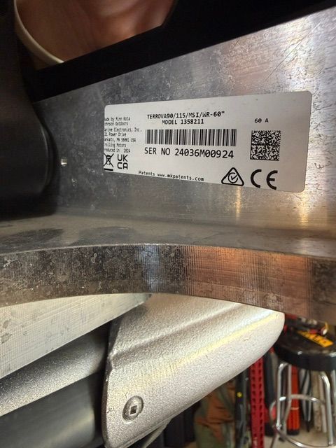 Close-up of a boat part with a label showing technical information and a serial number.