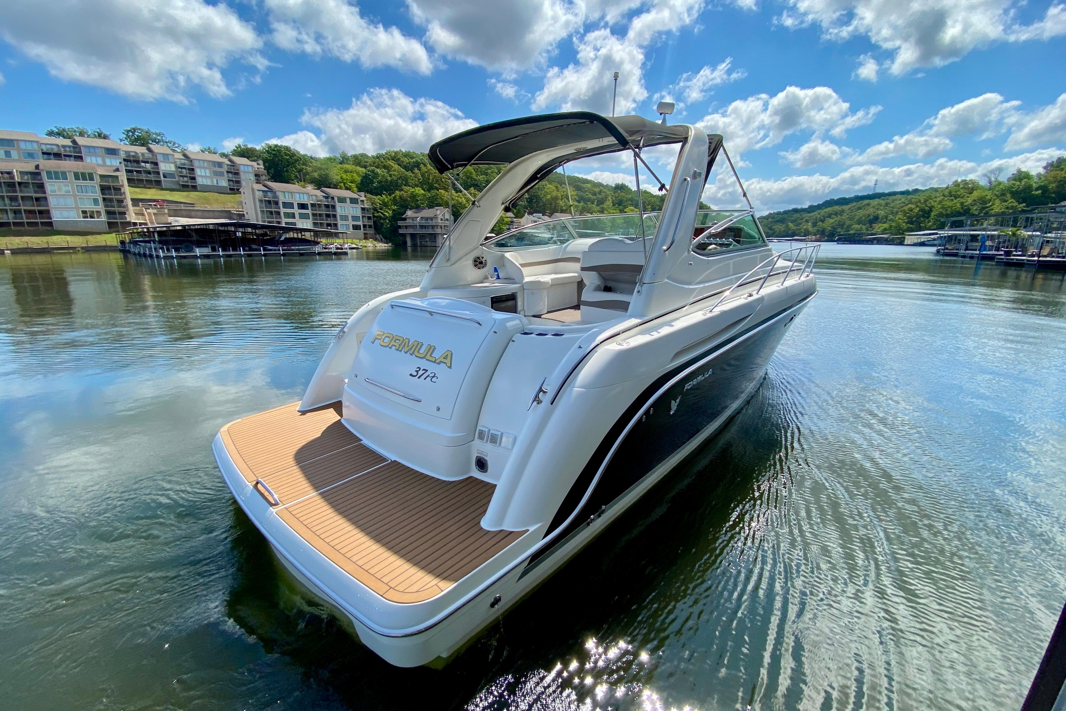 2004 Formula 37 PC yacht on serene lake with scenic backdrop.