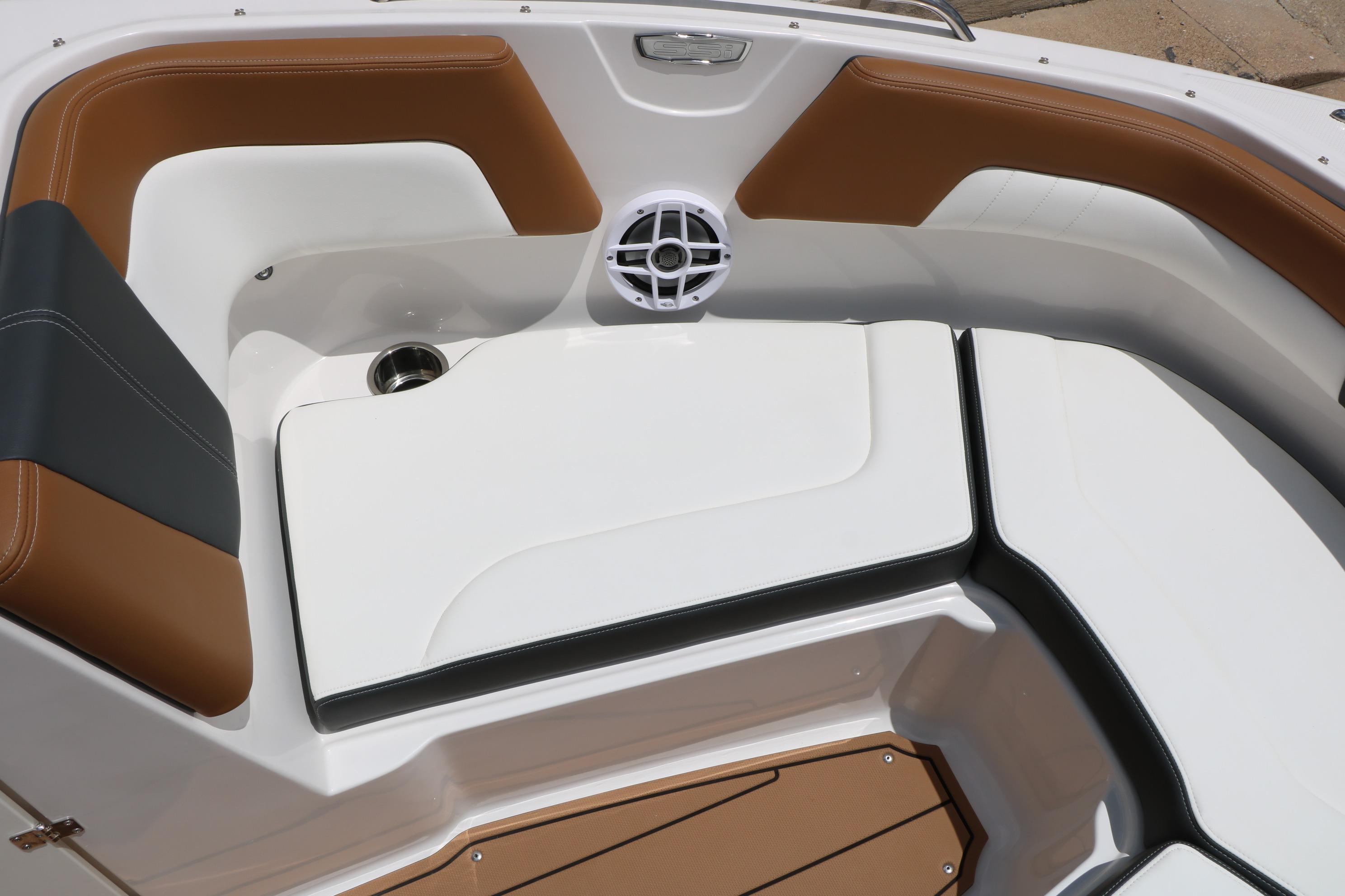 2025 Chaparral 23 SSi boat interior with brown and white seating, cup holder, and speaker.