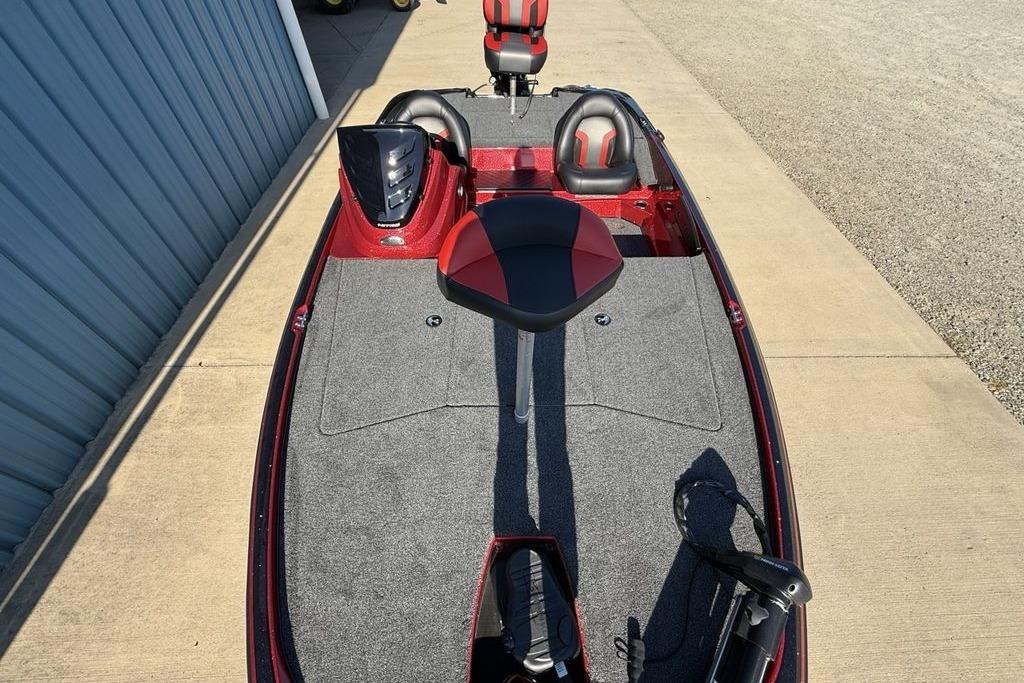 2026 Nitro Z17 boat with red and black seating, parked on concrete near a blue building.