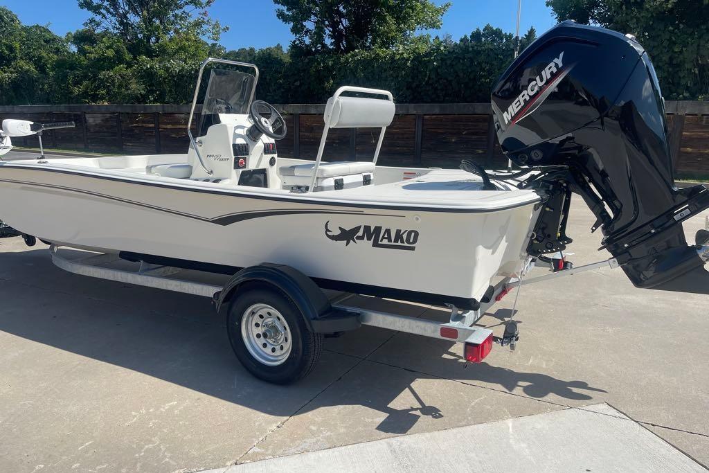 2026 Mako Pro Skiff 17 CC boat with Mercury engine on trailer, parked outdoors.