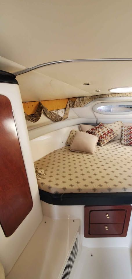 Interior of the 2002 Wellcraft 3300 Martinique with a cozy bed and decorative pillows.