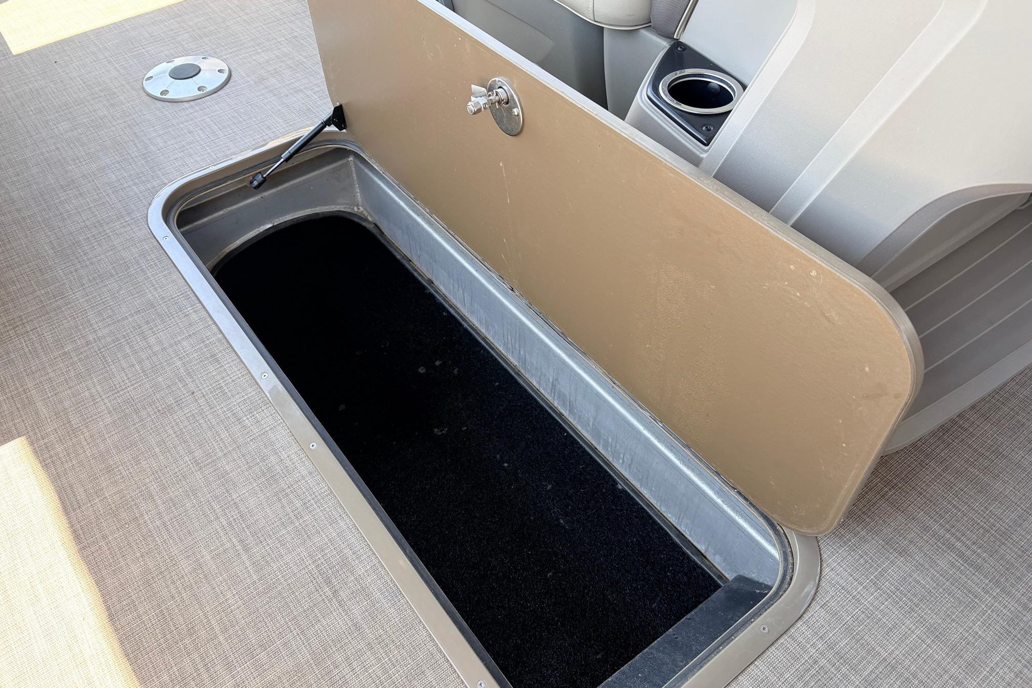 Open storage compartment on 2024 Sun Tracker SportFish 22 XP3 boat, featuring beige interior.