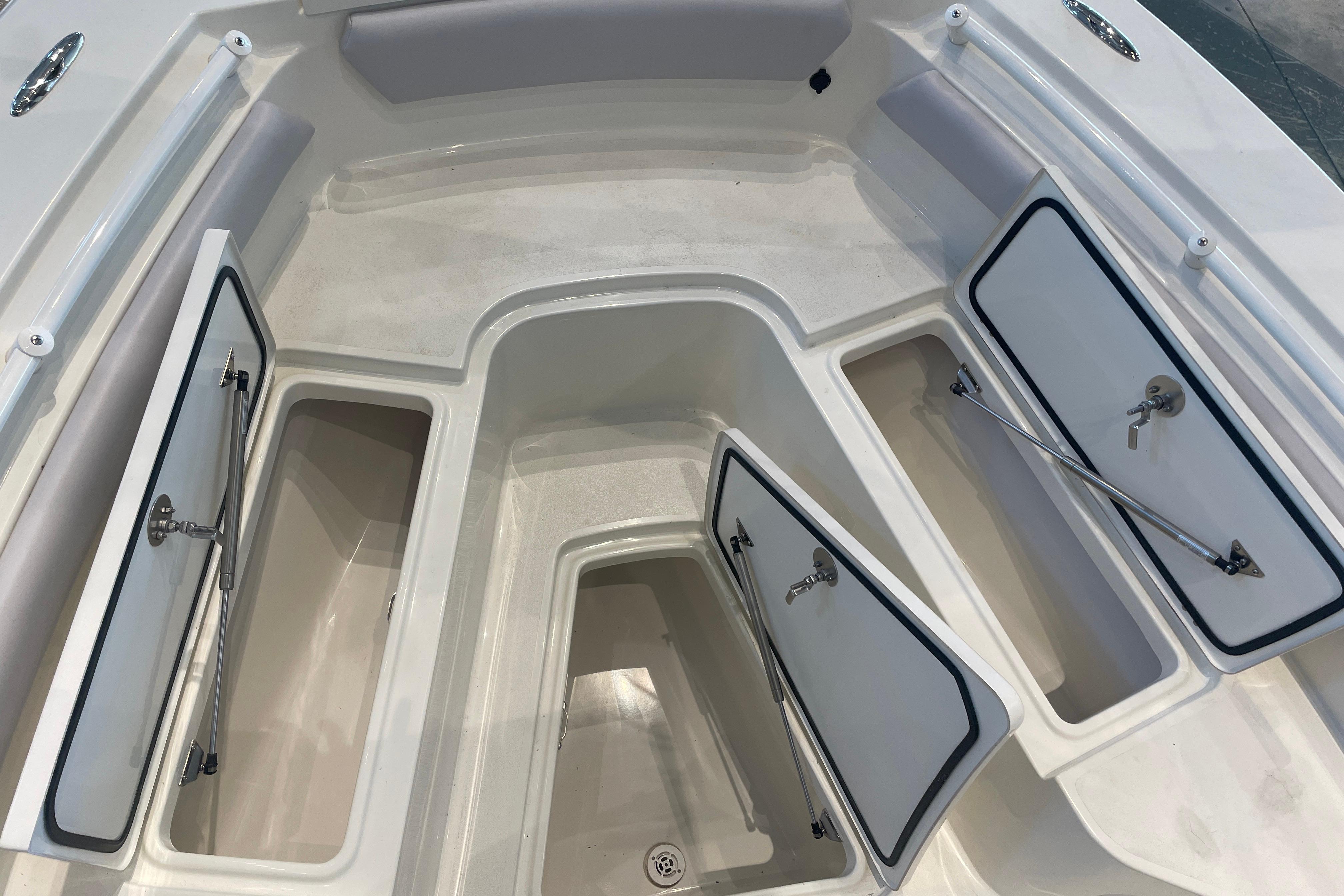 2026 Mako 226 Center Console boat storage compartments with open hatches.