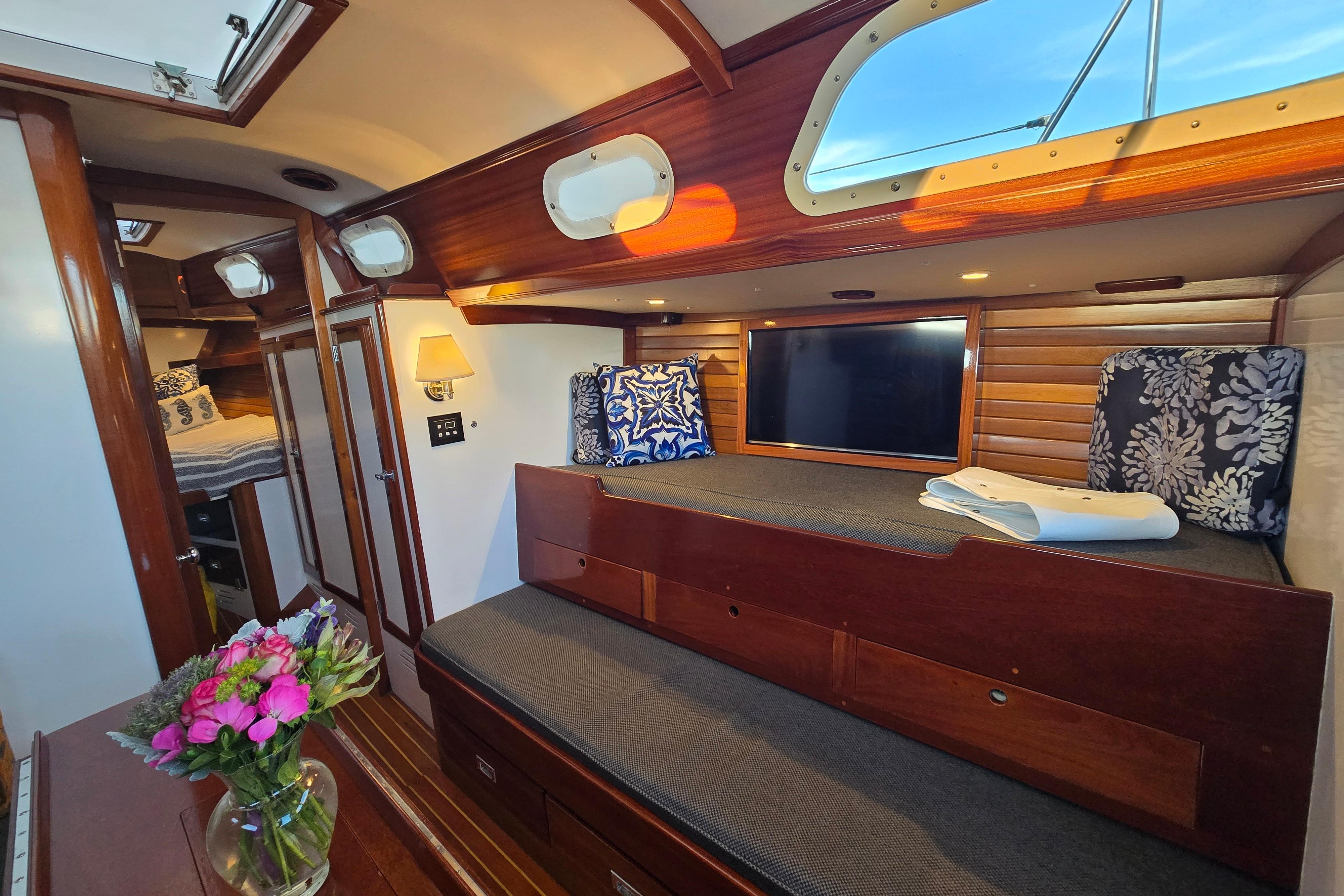 Interior of a 1970 Hinckley Bermuda 40 yacht with cozy seating and elegant wood finishes.