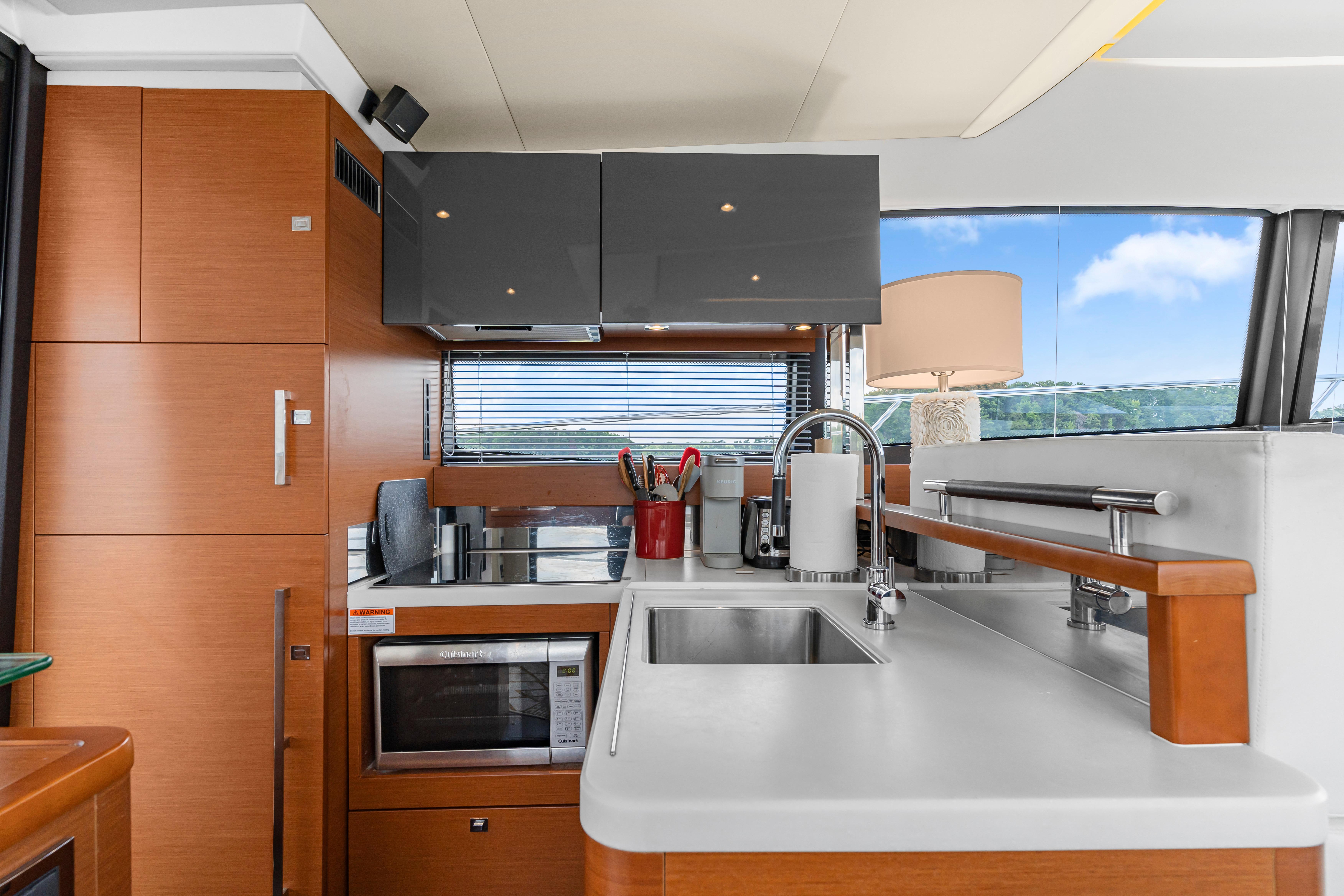 Modern kitchen interior on a 2017 Prestige 500 yacht, featuring sleek cabinetry and appliances.