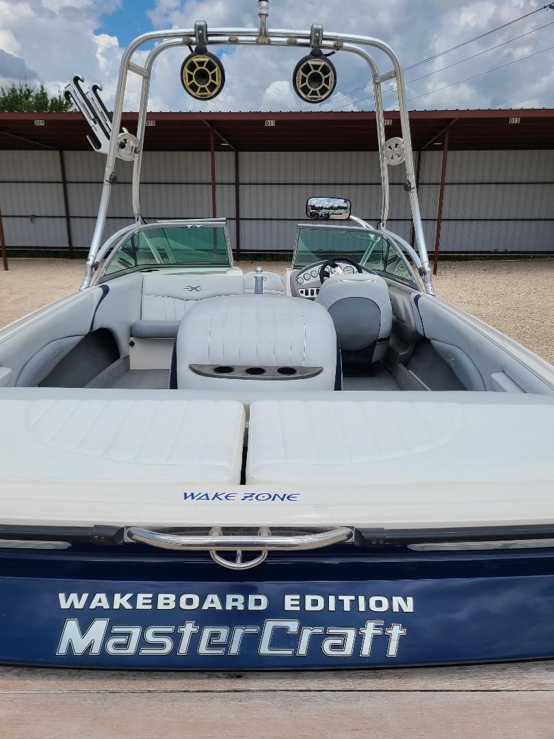 2003 MasterCraft X-9 Wakeboard Edition boat with tower speakers and spacious seating.