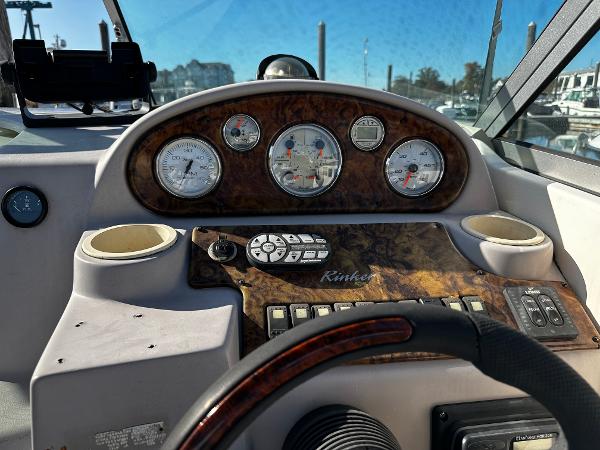2004 Rinker Fiesta Vee 250 dashboard with gauges and controls, featuring wood accents.