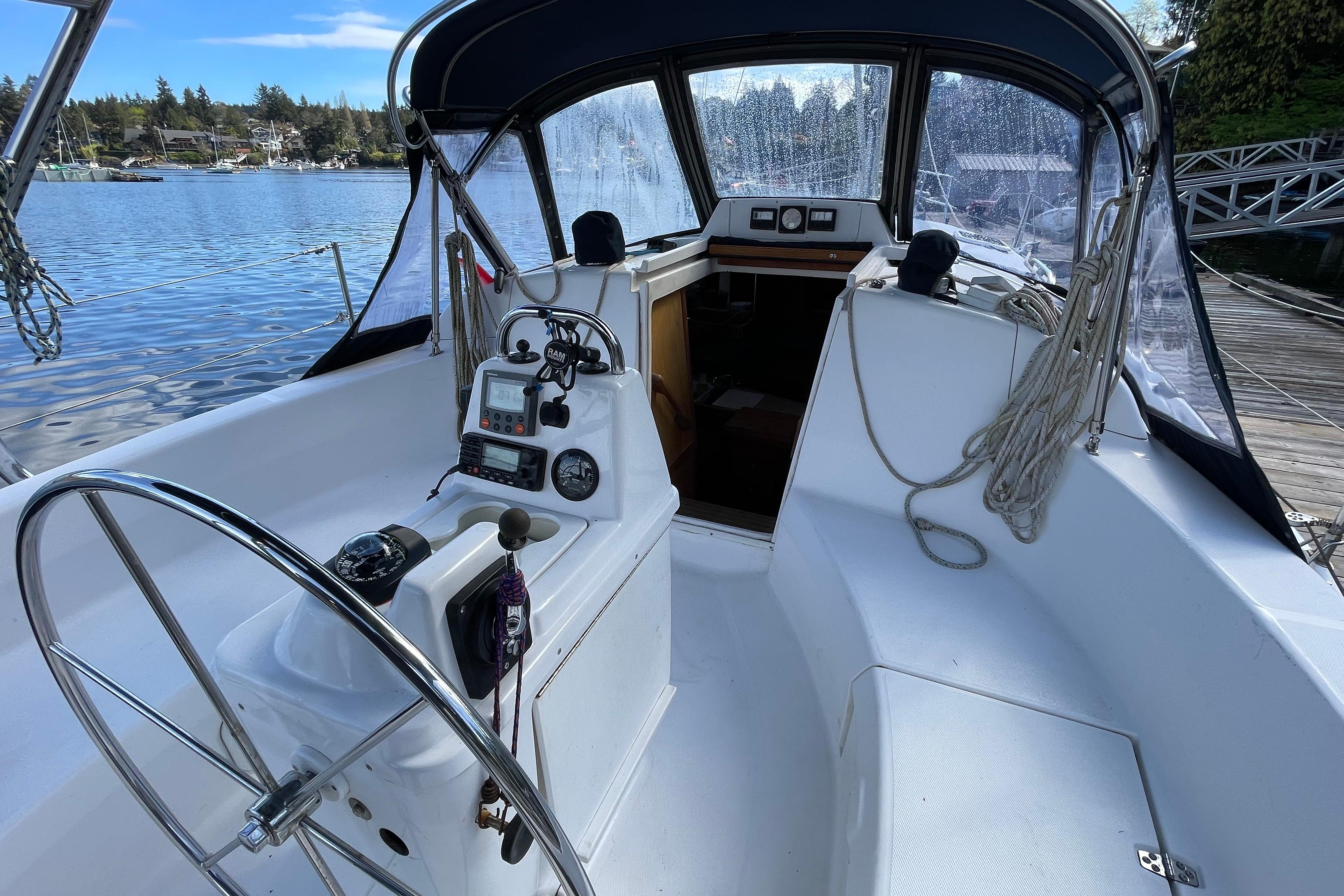 2000 Hunter 340 sailboat cockpit with steering wheel, navigation instruments, and marina view.