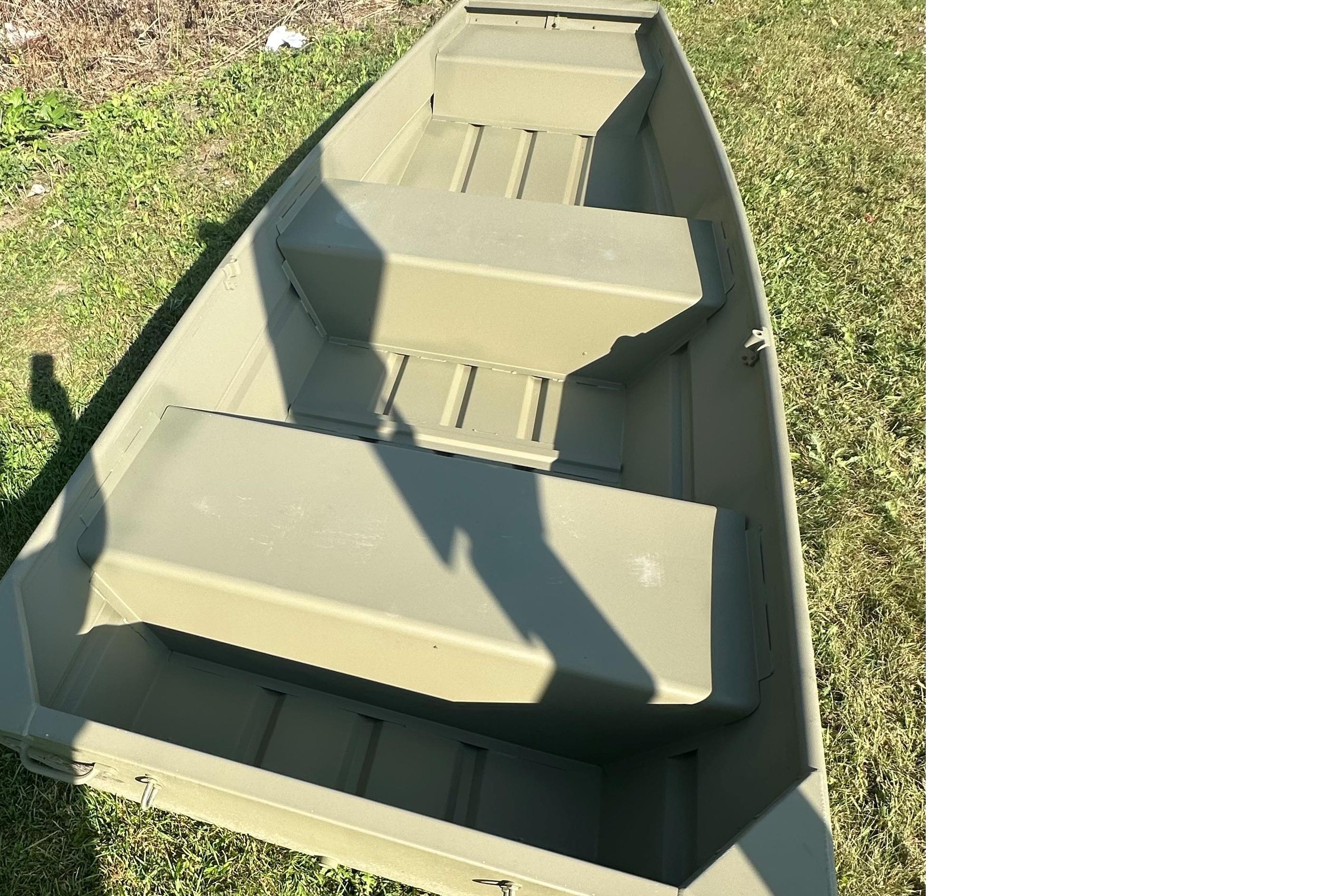 2026 Tracker Grizzly 12 Jon boat on grass, showcasing interior seating and structure.