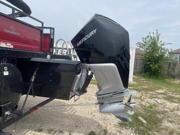 2023 Regency 250DL3 boat with Mercury outboard motor, parked on gravel.
