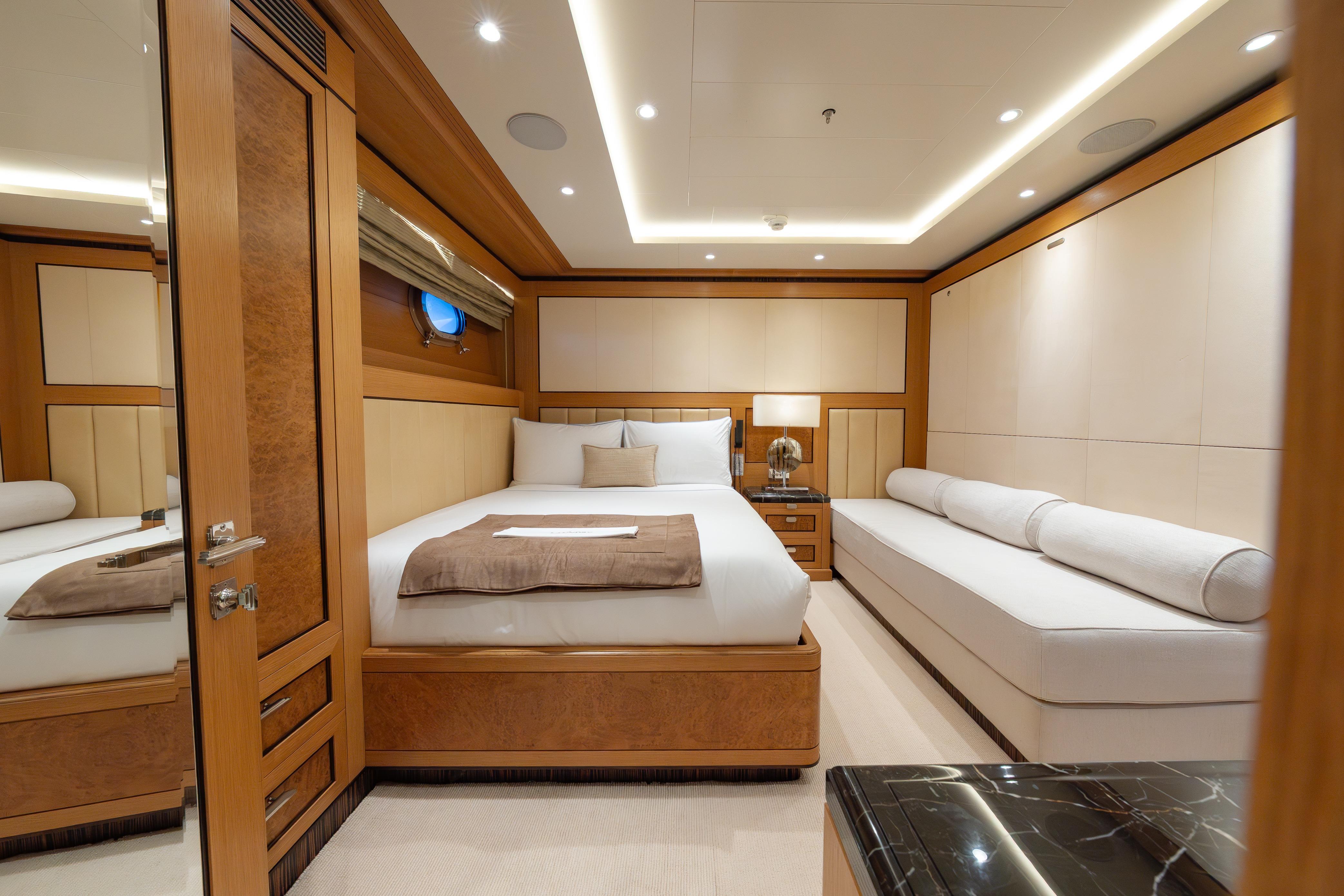 Luxurious bedroom on 2009 Timmerman Expedition Tri-Deck yacht, featuring elegant wood and modern design.
