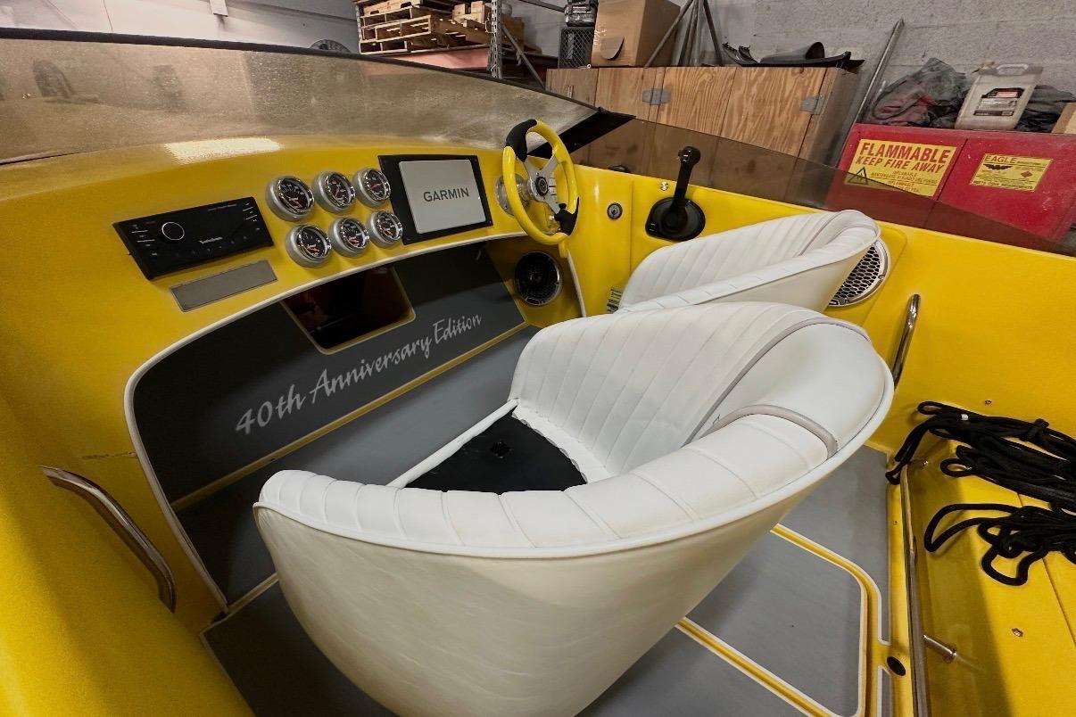 Interior of a 2004 Donzi 22 Classic boat, 40th Anniversary Edition, featuring white seats and yellow dashboard.