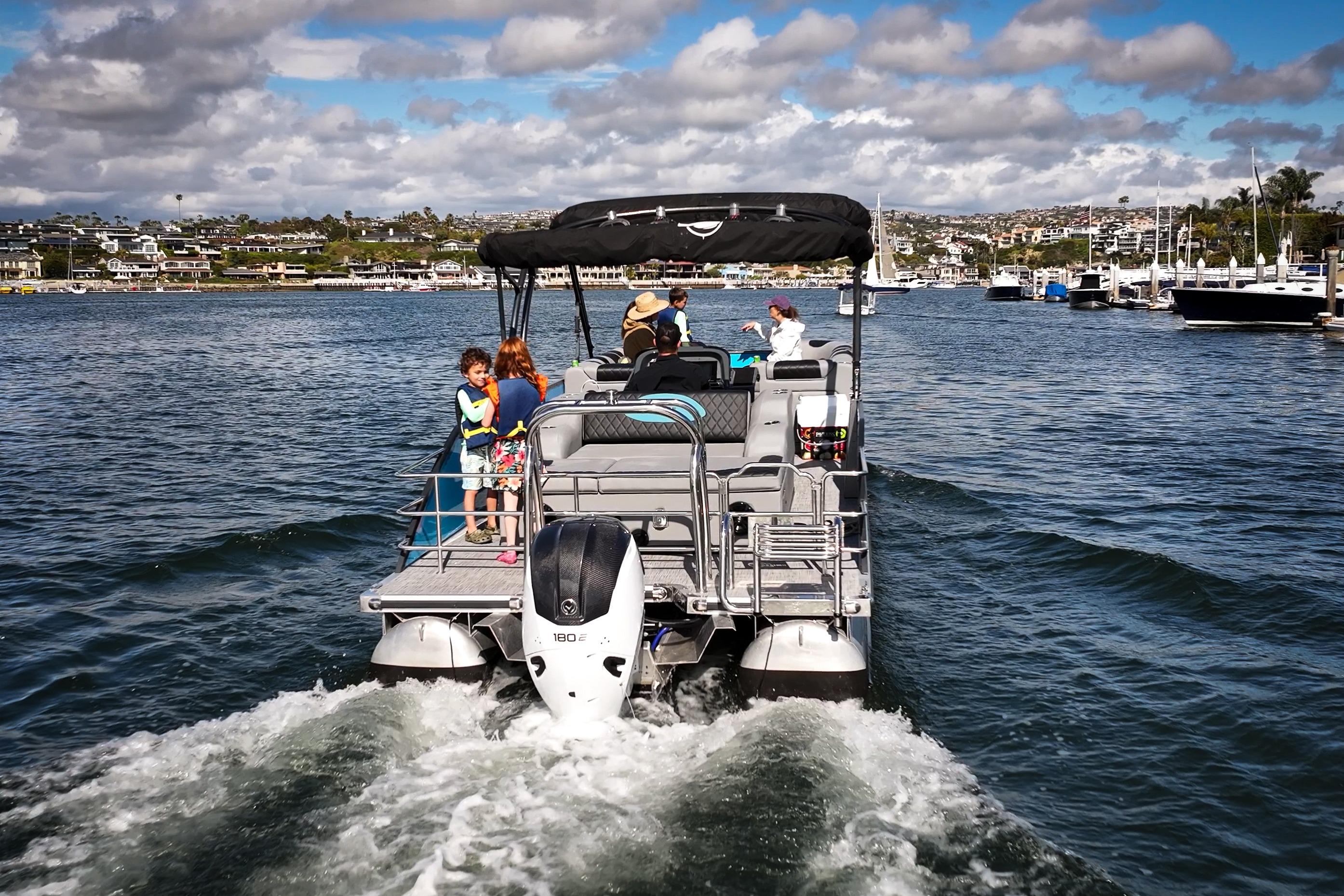 2025 Vision Marine Technologies V30 boat cruising on a sunny day with passengers onboard.