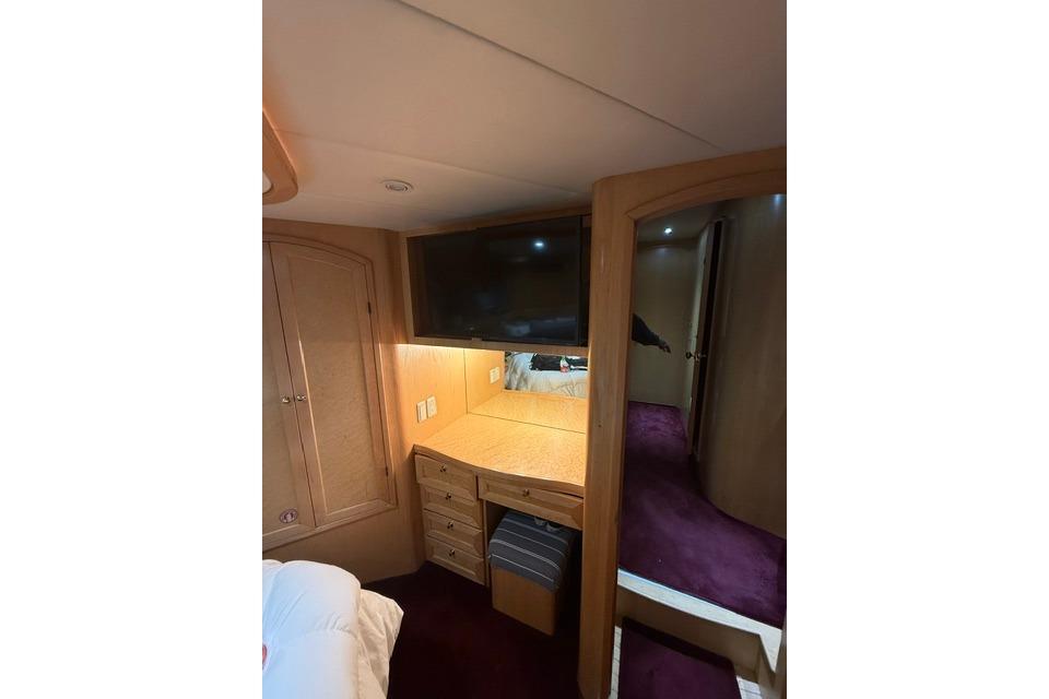 Interior of 1999 McKinna 57 Pilothouse with desk, TV, and wooden cabinetry.