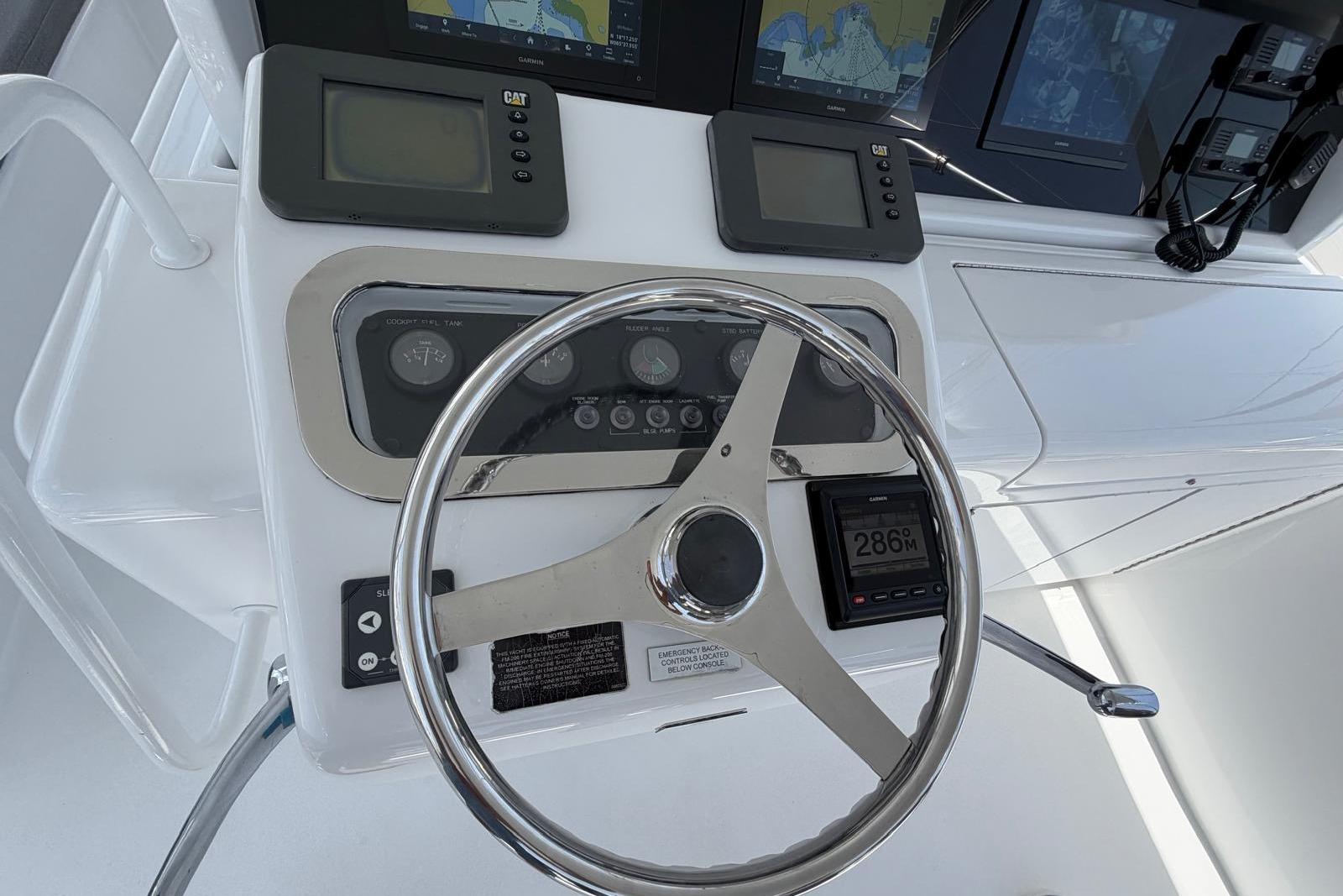 Helm of 2003 Hatteras 54 Convertible with navigation instruments and steering wheel.