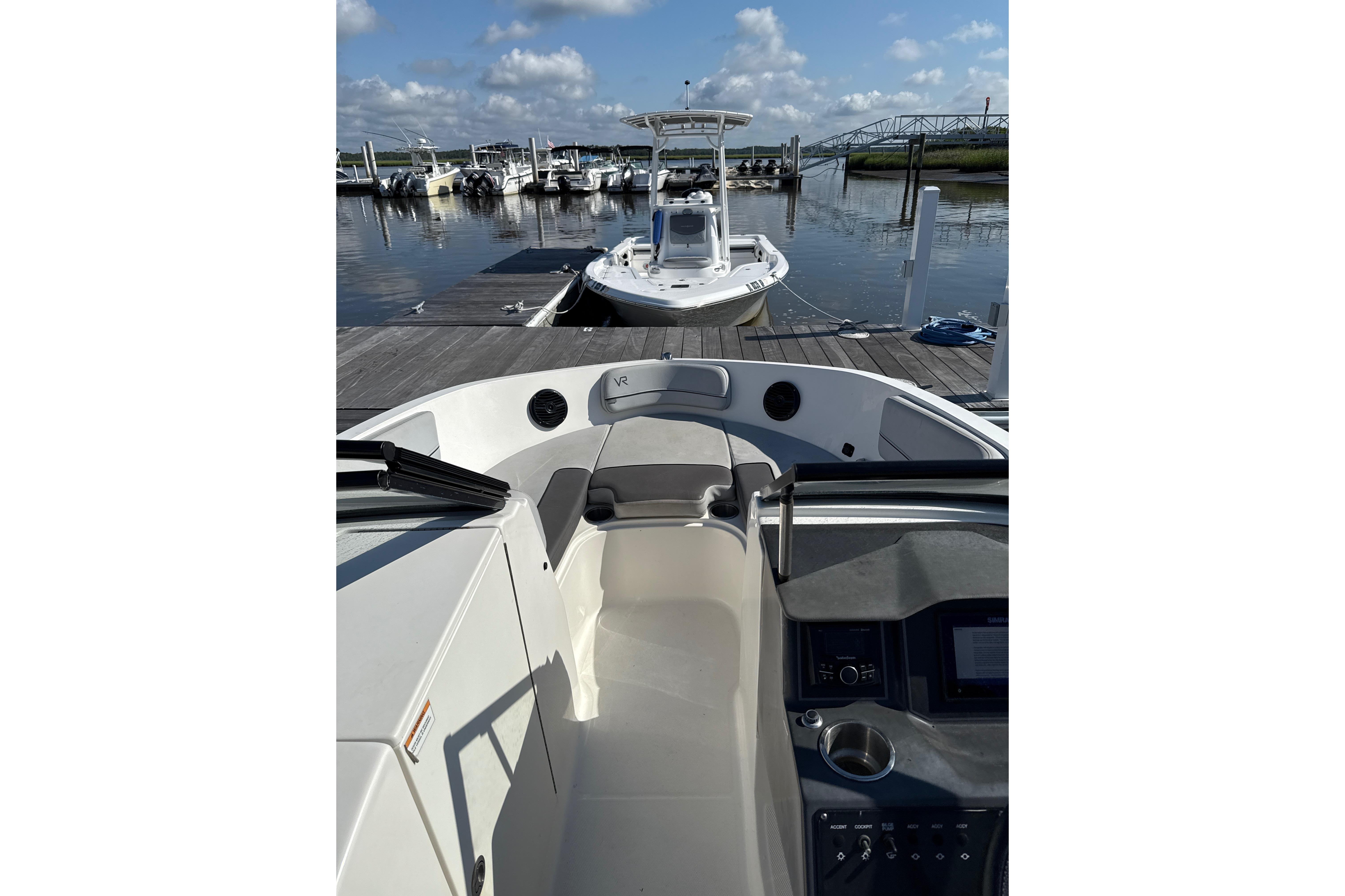2023 Bayliner VR6 Bowrider OB at marina, clear sky, docked boats in background.