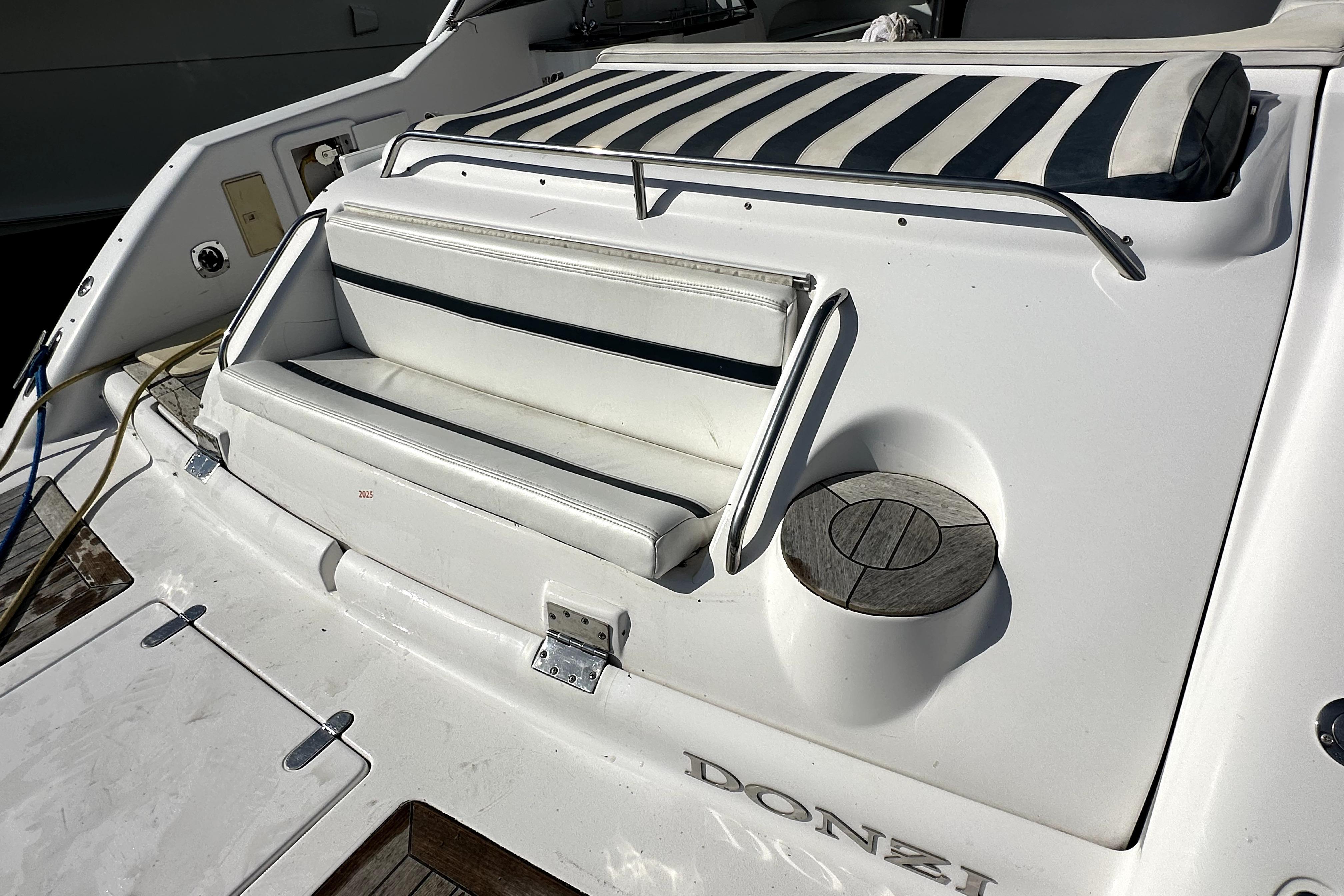 2003 Donzi 39 ZSC boat with white seating and striped cushion on deck.
