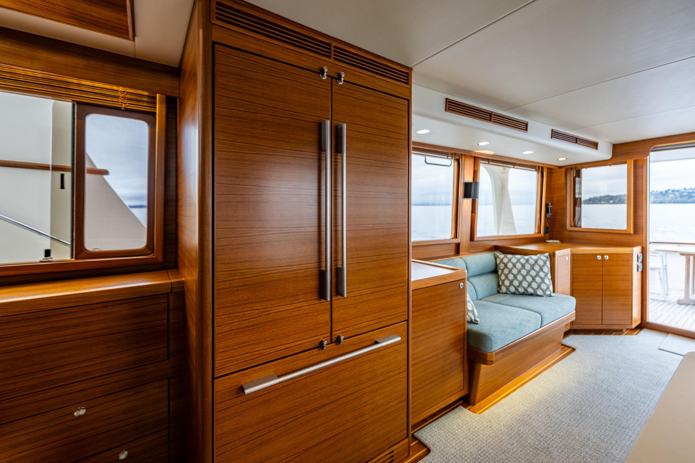 Luxurious interior of 2026 Fleming 55 Pilothouse yacht with elegant wood finishes and seating.