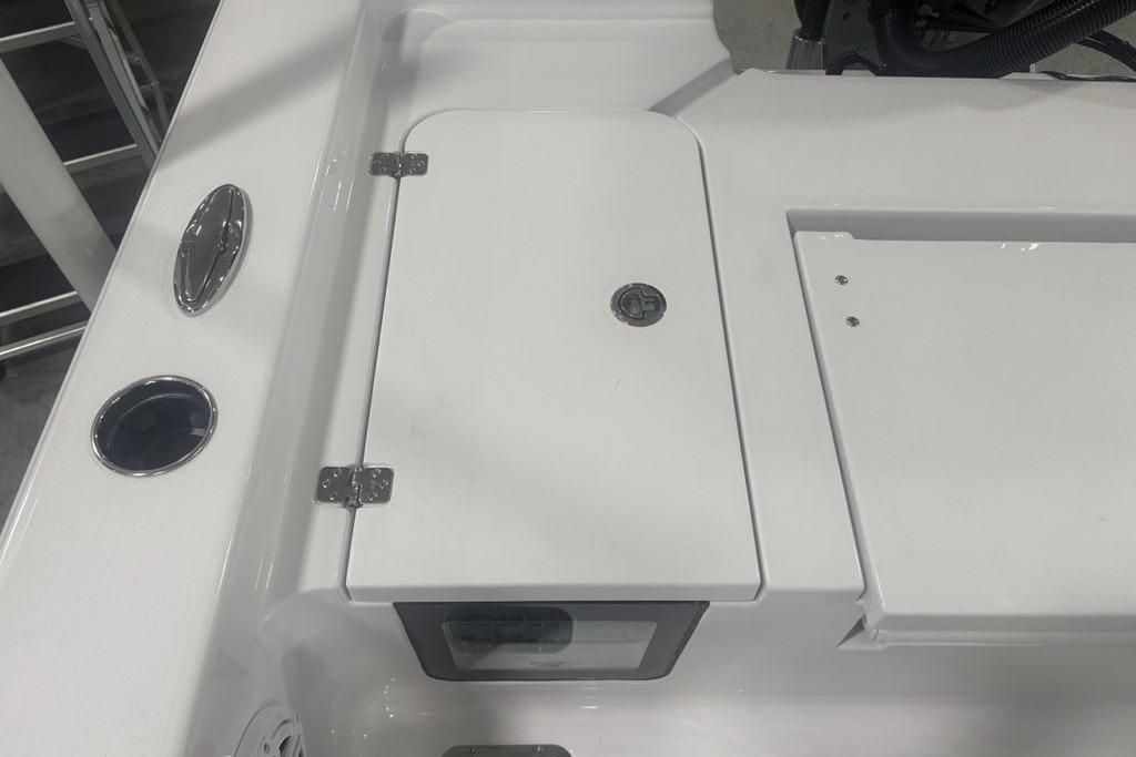 2026 Sportsman Masters 227 boat deck with storage compartment and chrome fixtures.