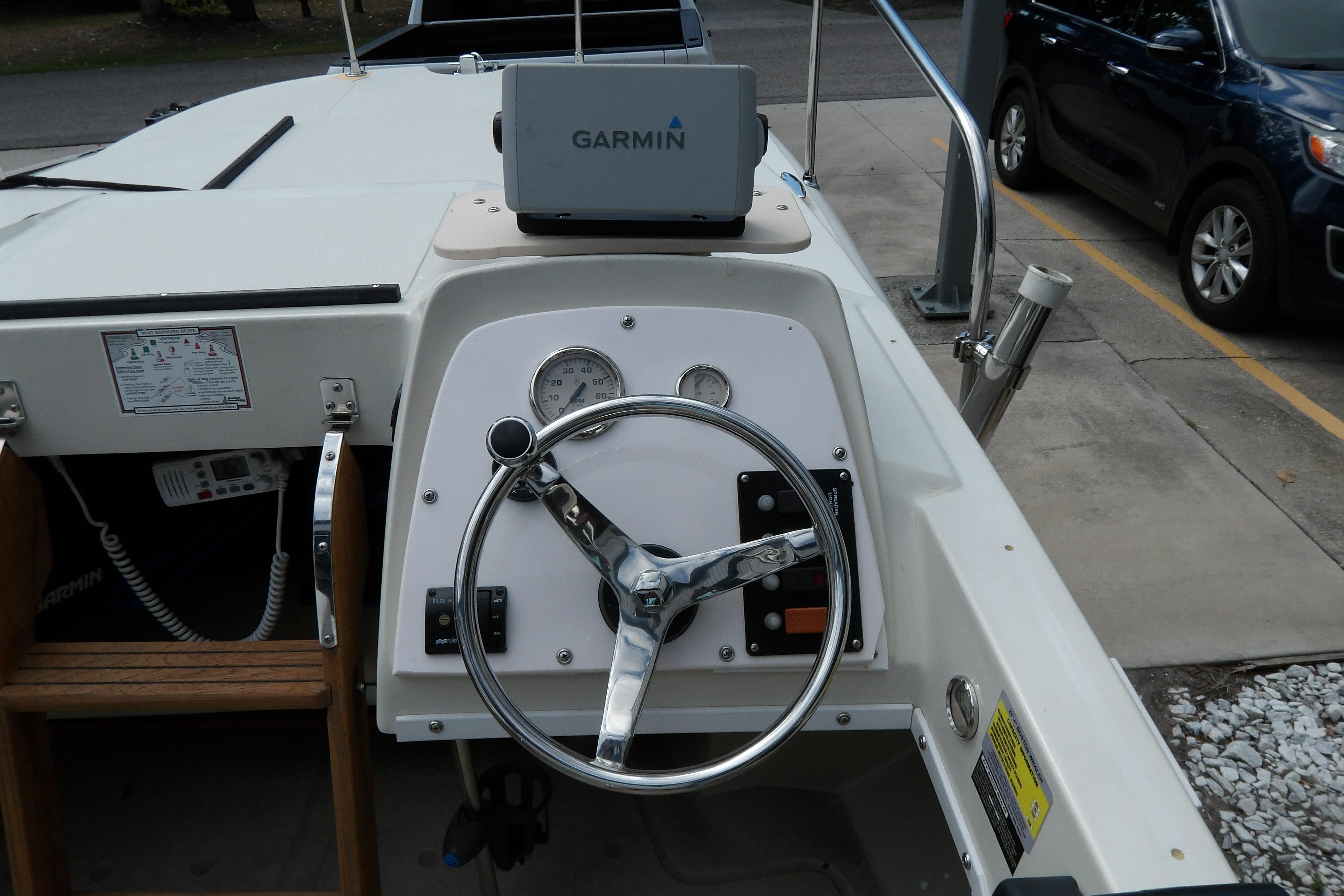 1978 Boston Whaler 21 Revenge boat dashboard with Garmin GPS and steering wheel.