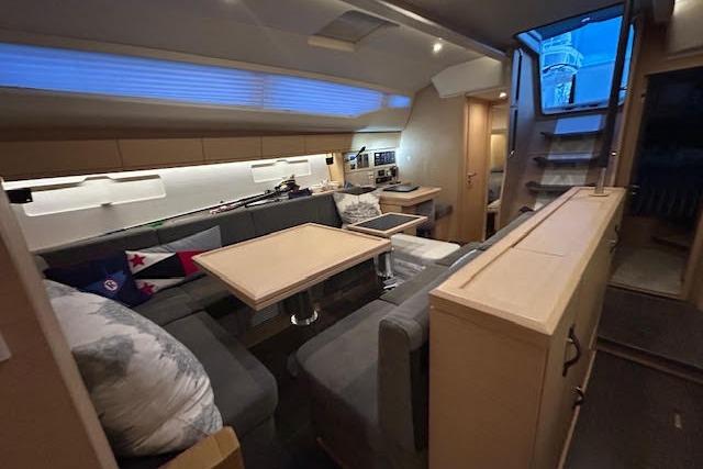 Luxurious interior of a 2016 Jeanneau 54 yacht with modern seating and dining area.