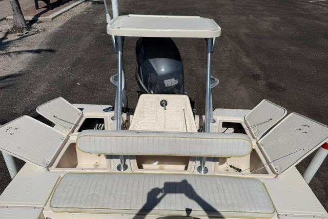 2002 Key West 1760 Stealth boat with open storage compartments and outboard motor.
