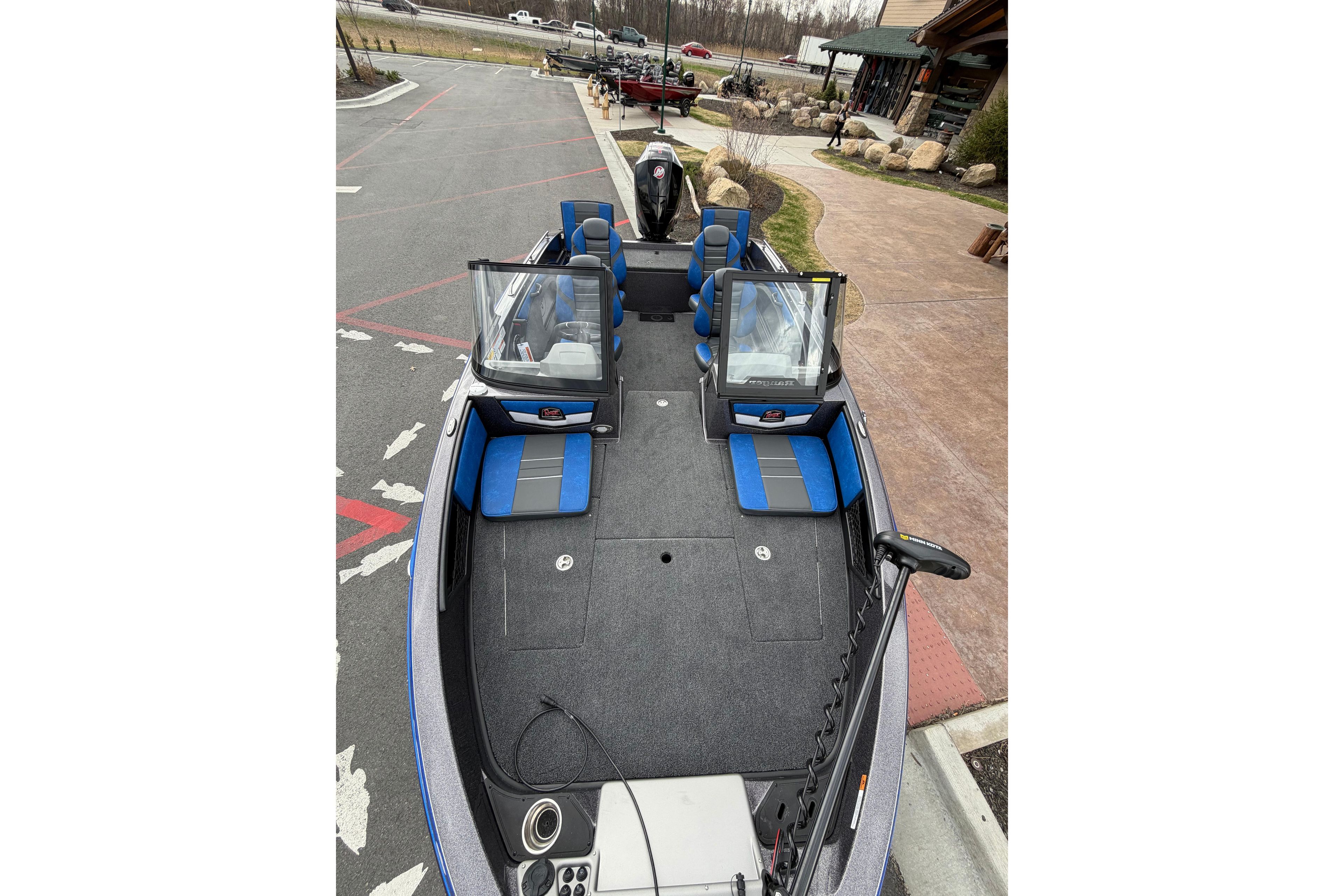 2026 Ranger 1880MS boat with blue seating, parked outdoors near a building.