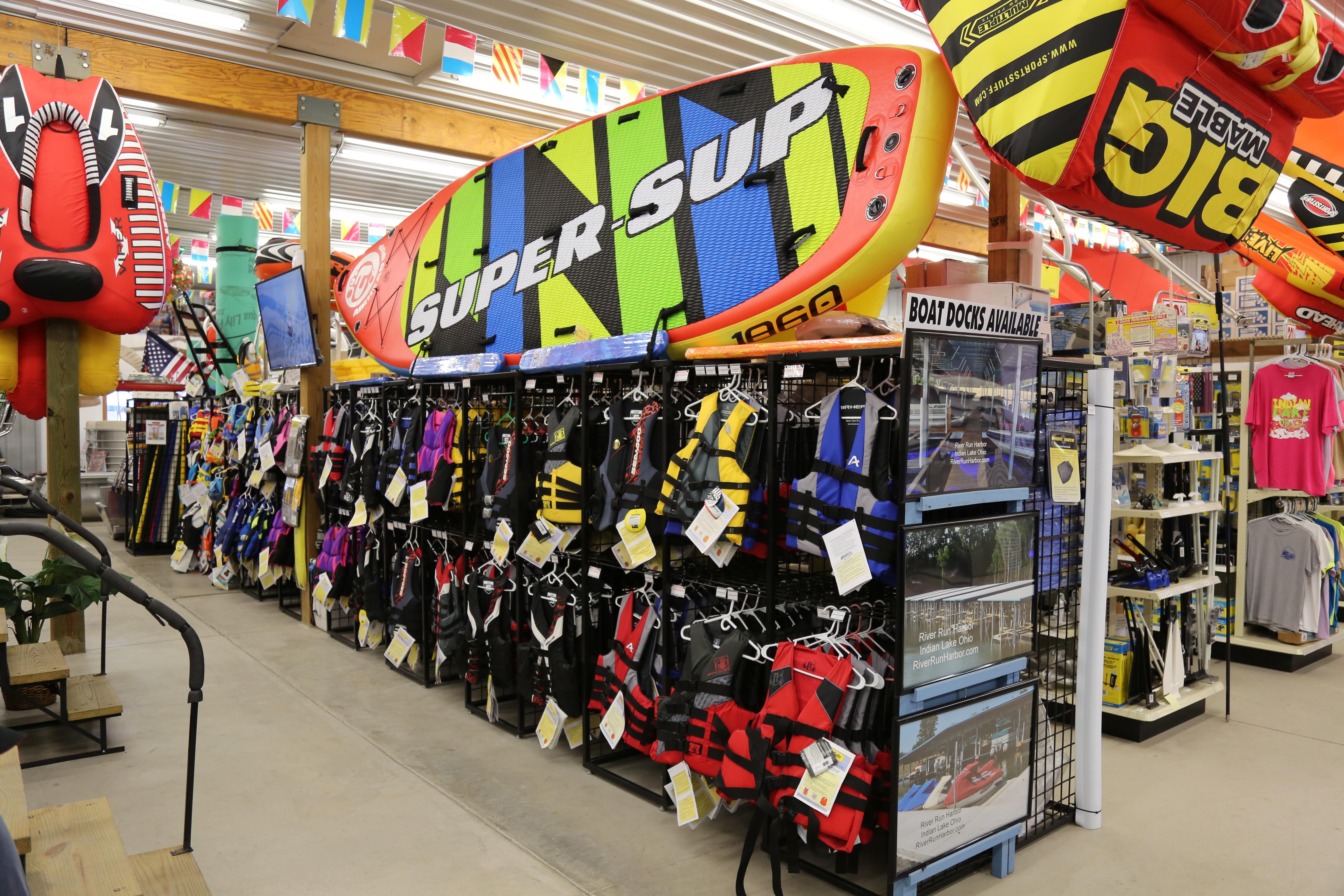 Watersports store with life jackets and inflatable boards.