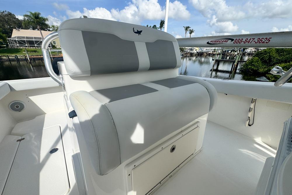 2018 Mako 284 Center Console boat interior with cushioned seating and storage, dockside view.
