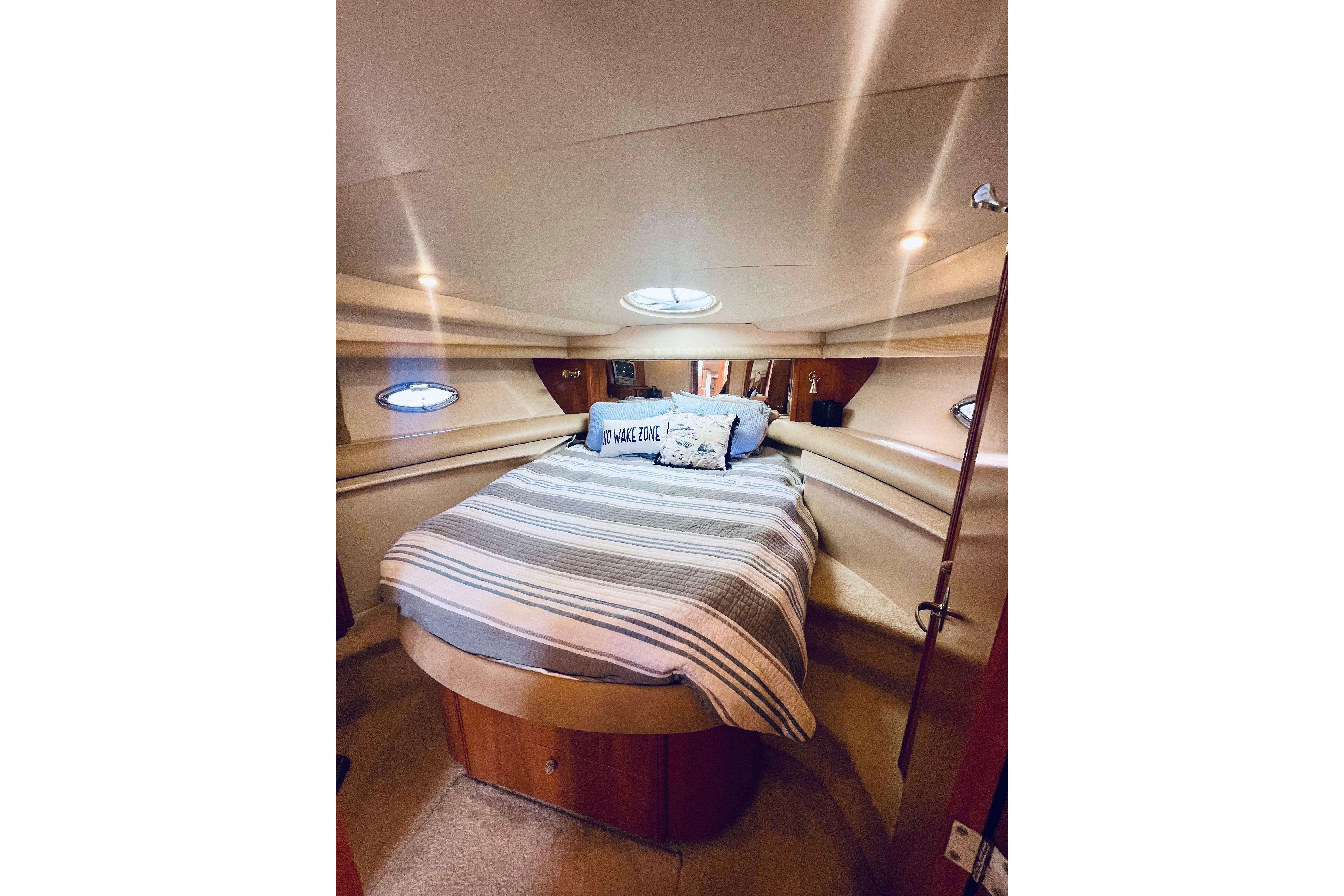 Luxurious bedroom interior of 2004 Meridian 459 Motoryacht with cozy bedding and ambient lighting.
