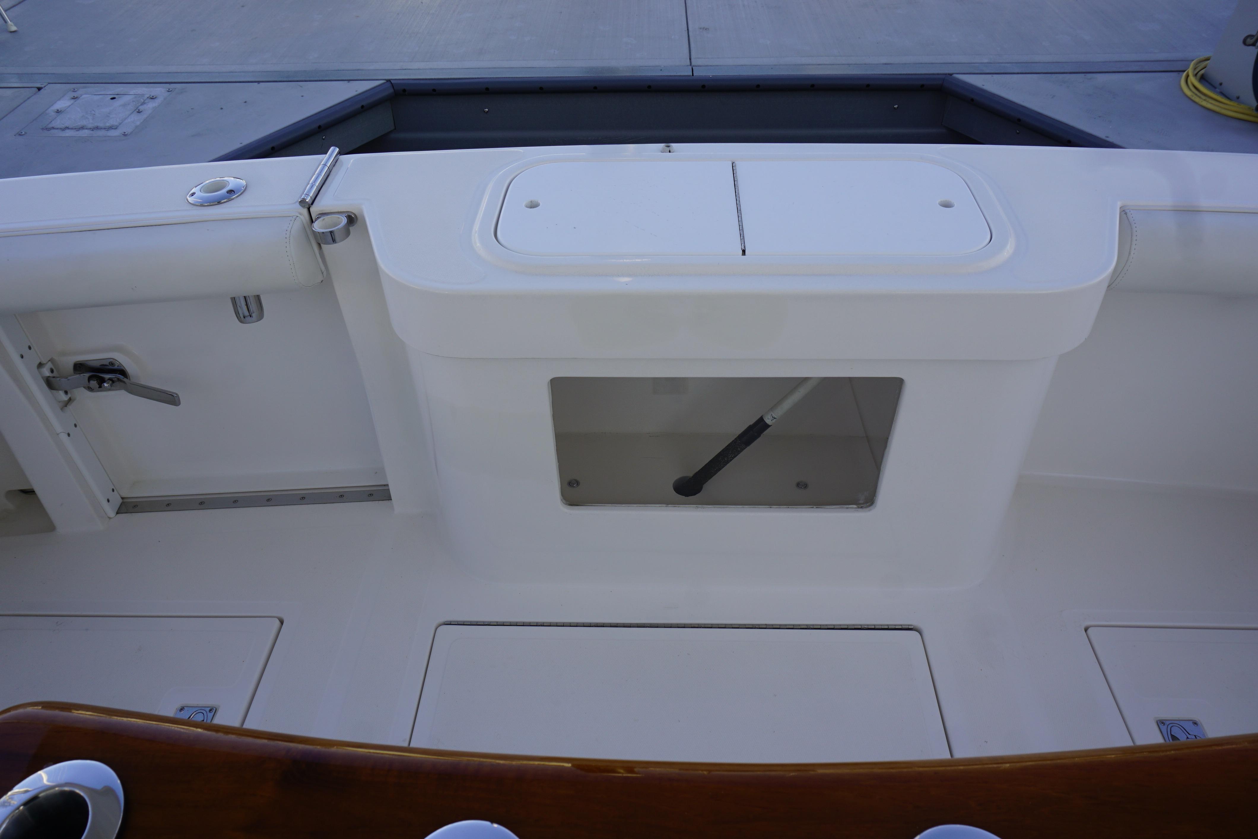 2005 Cabo 35 Express boat deck with storage compartments and fishing rod holder.