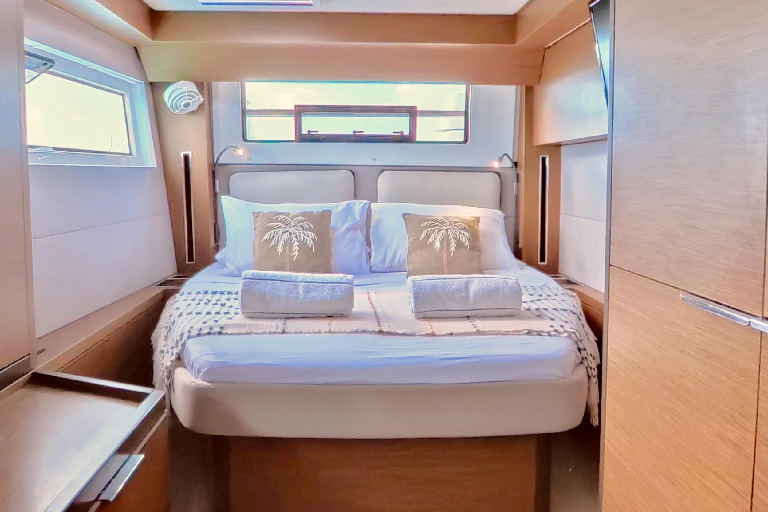Luxurious cabin interior of 2023 Lagoon 50 yacht with cozy bed and elegant decor.