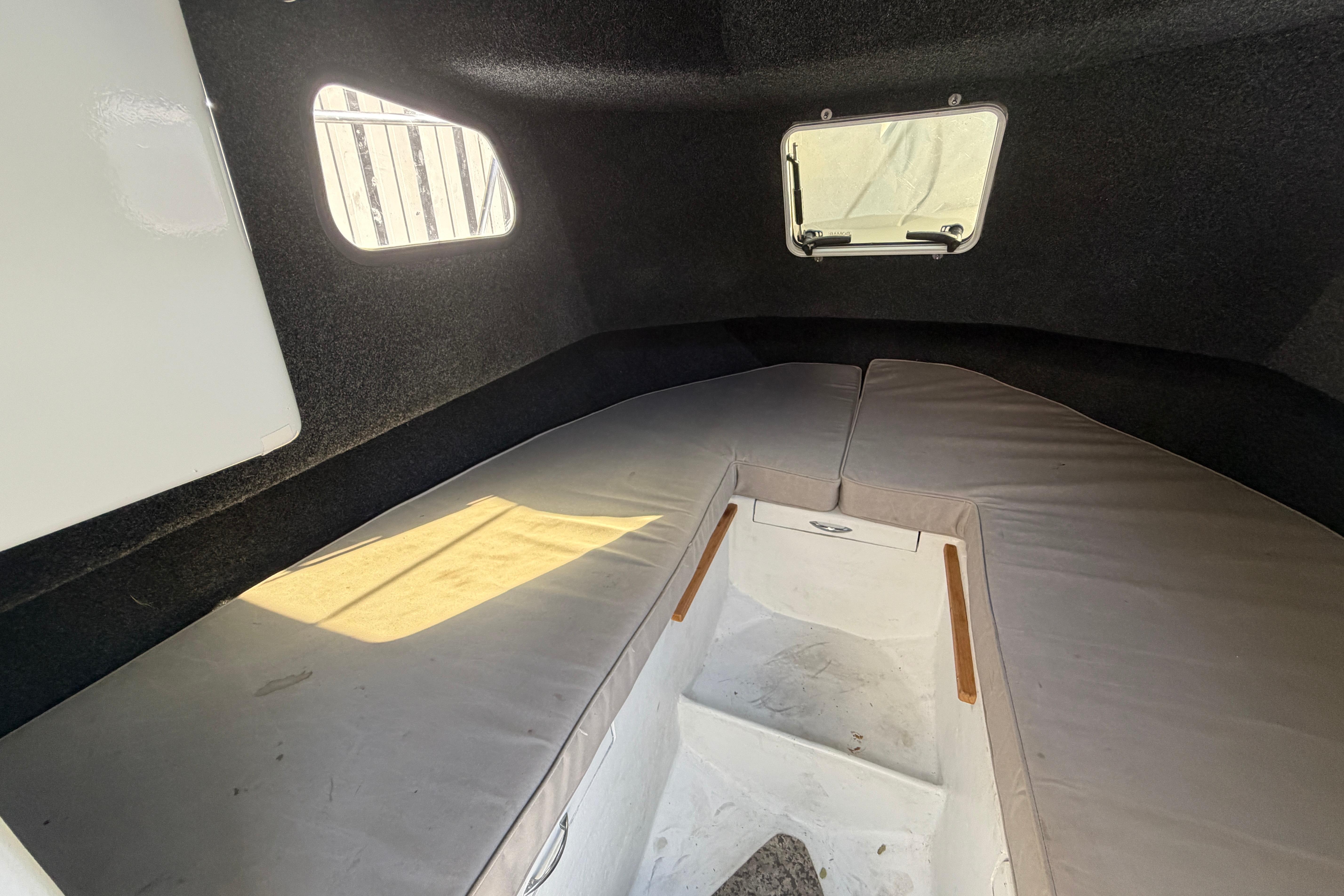 Interior cabin of a 1986 Radon 21 Sport boat with cushioned seating.