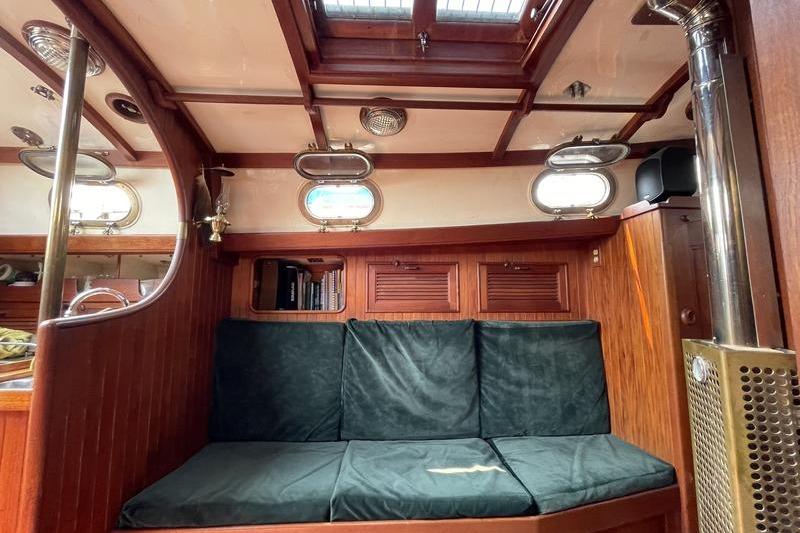 Interior of 1980 Ta Shing Baba 30 sailboat with wooden paneling and cushioned seating.