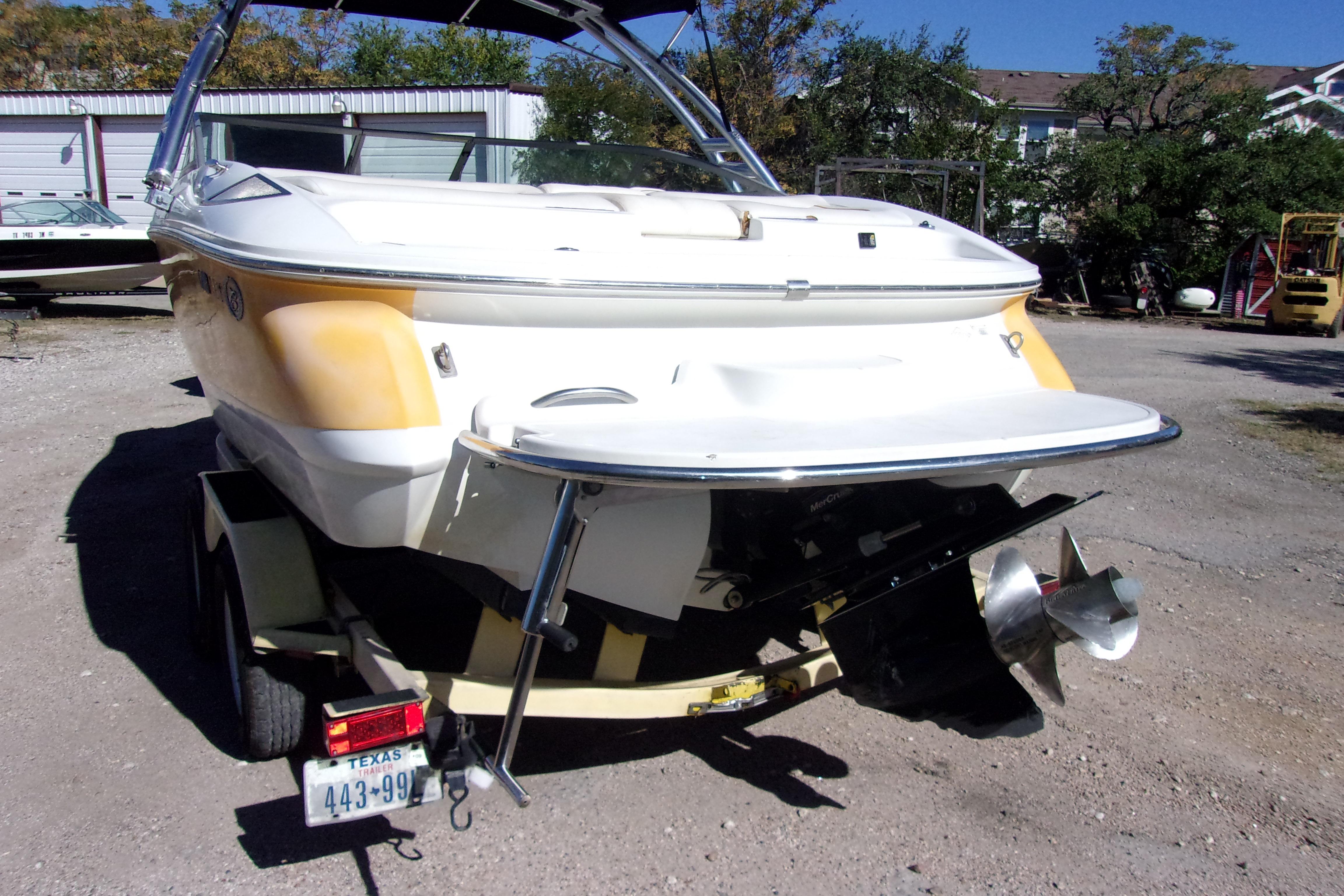 2005 Cobalt 200 boat on trailer, rear view with propeller, parked outdoors.