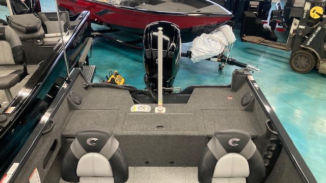 2025 Crestliner 1650 Hawk boat interior with seating and motor, displayed in showroom.