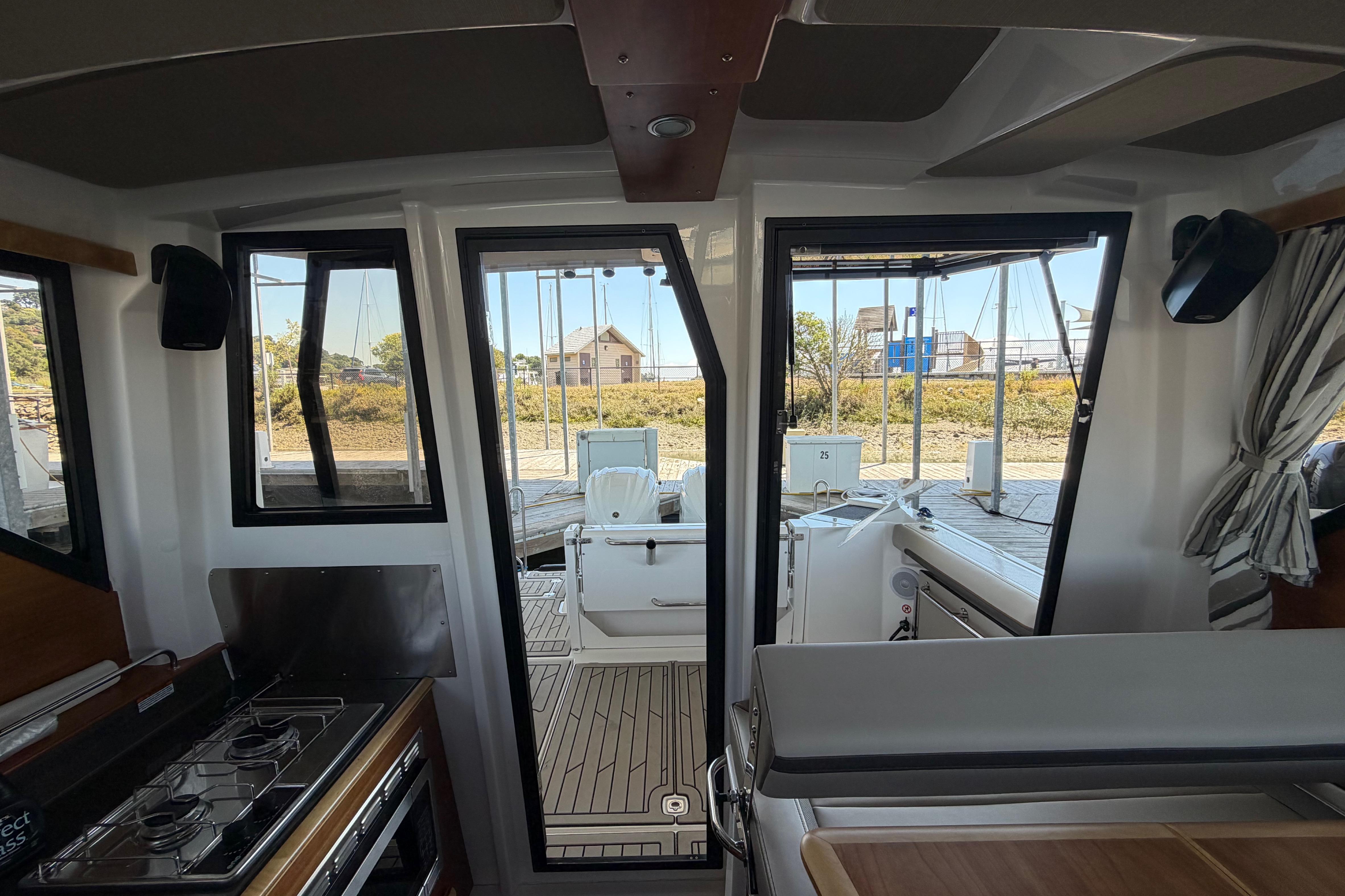 2023 Cutwater C-288 Coupe interior with modern kitchen and outdoor view.