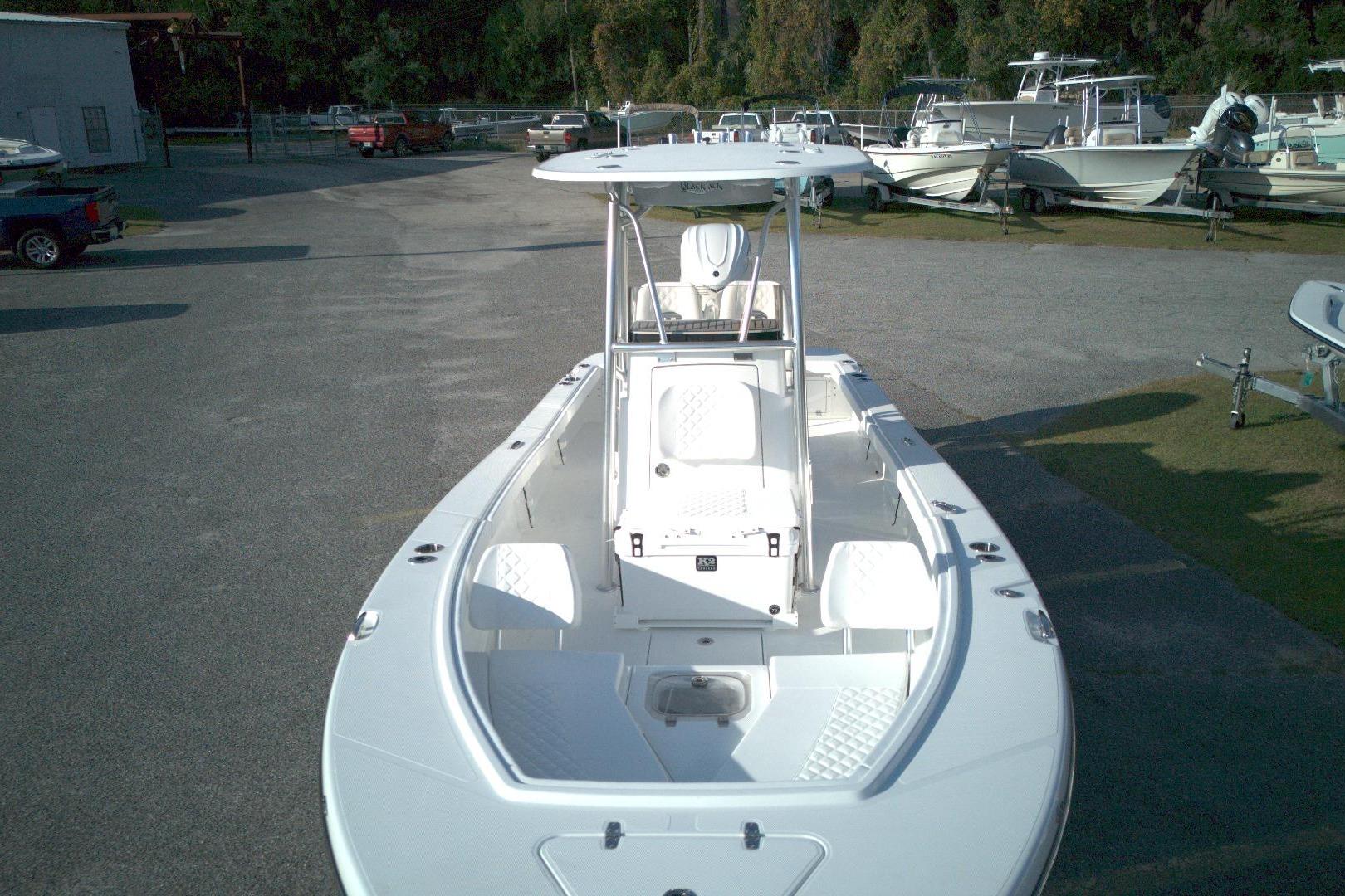 2026 BlackJack 256 Coastal boat in a marina, showcasing sleek design and spacious deck.