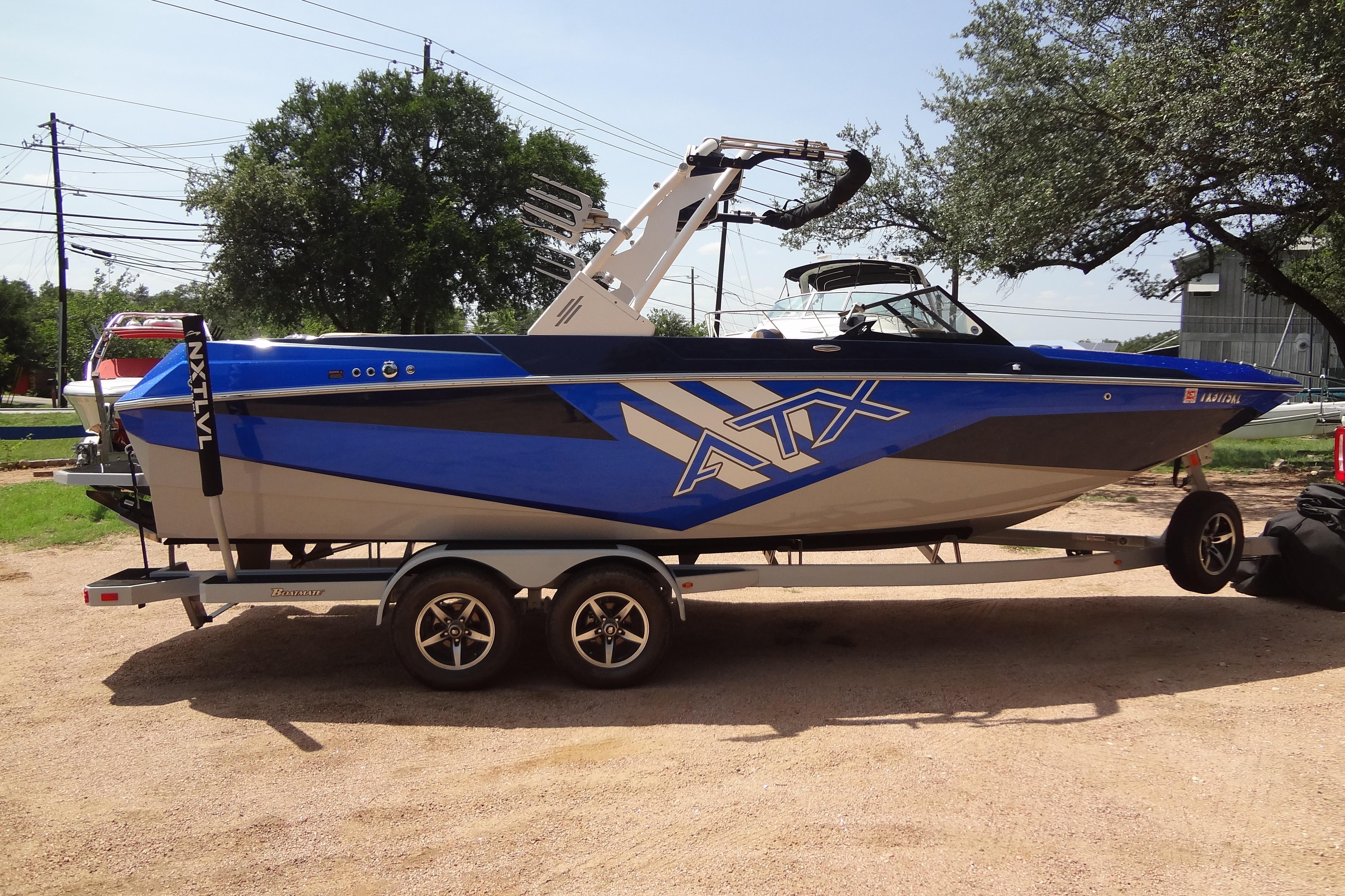 2022 ATX Surf Boats 24 Type-S in blue, parked on a trailer outdoors.