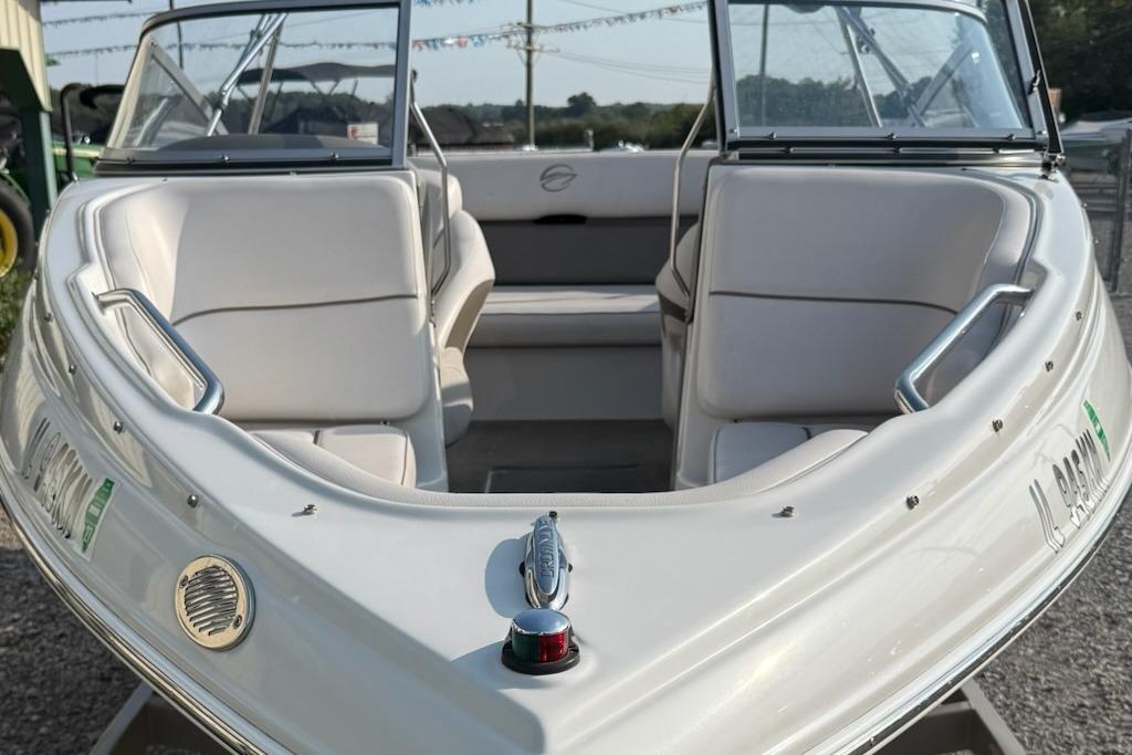 2012 195 SS boat with white seating and sleek design, docked outdoors.
