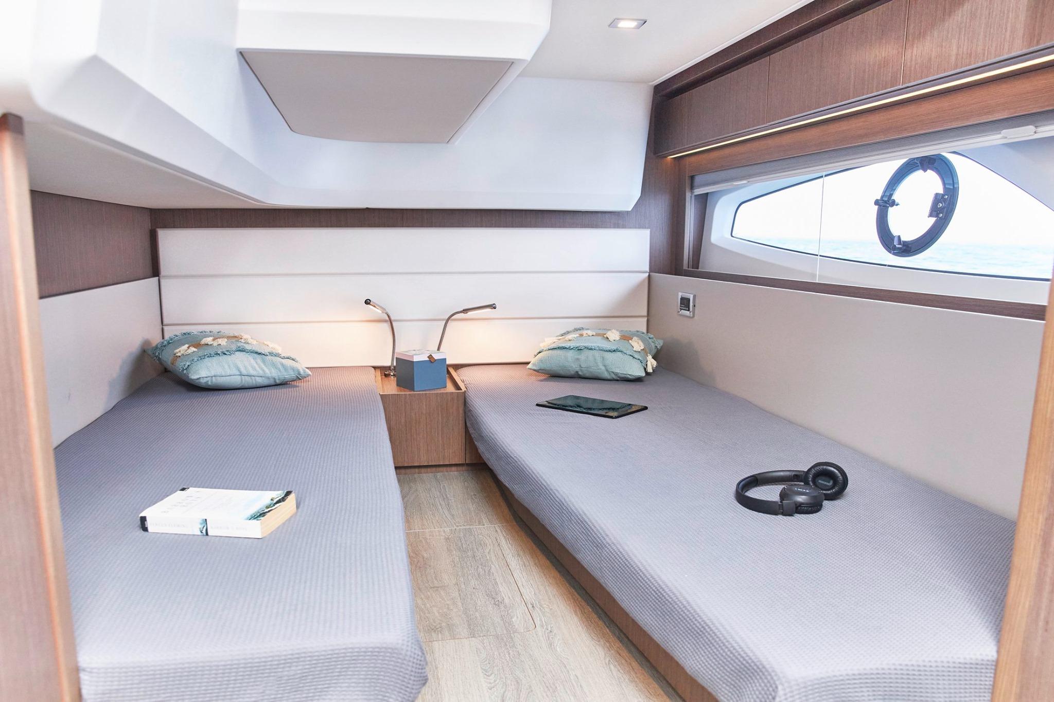 2026 Sealine C390 cabin interior with twin beds, modern decor, and natural light.