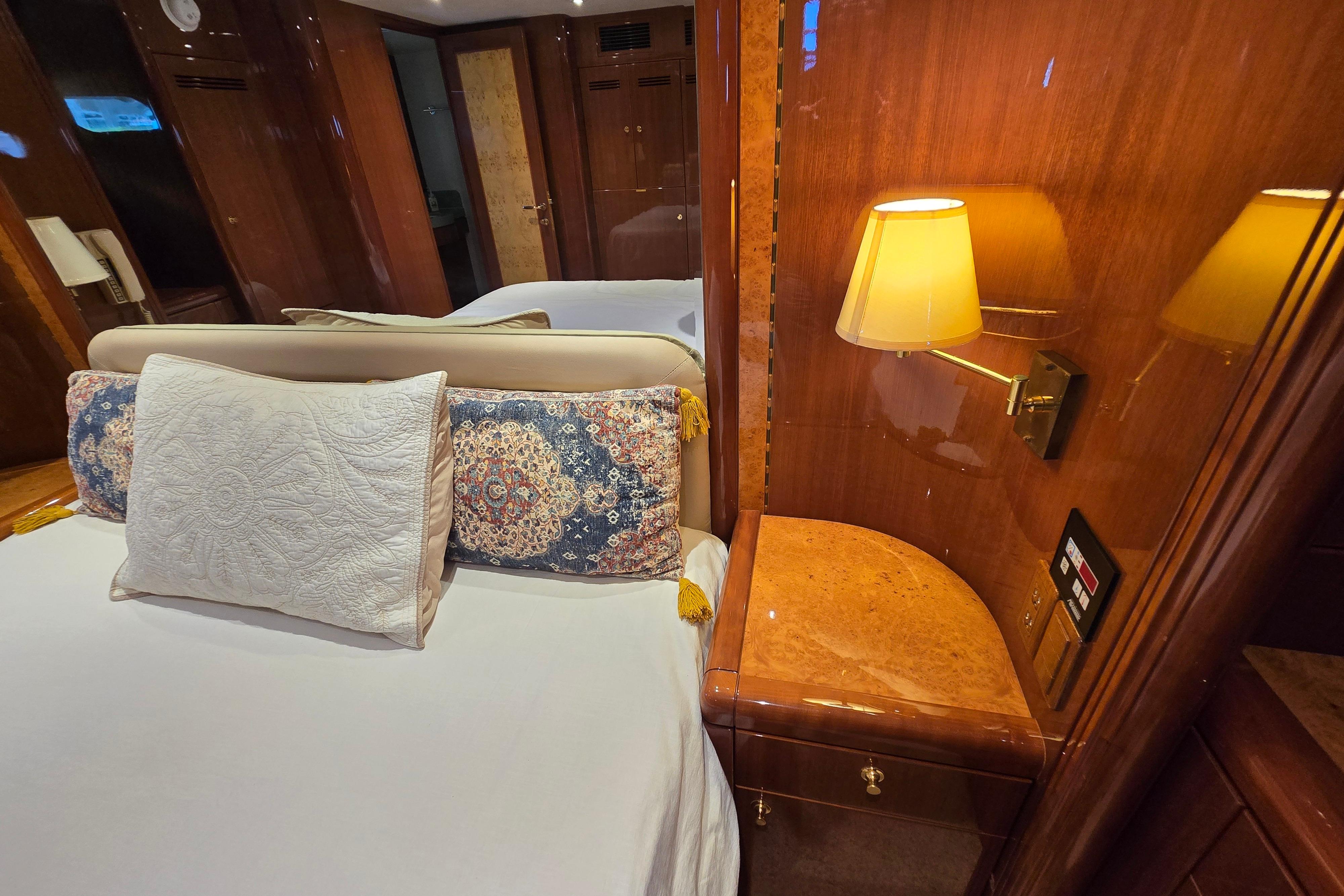 Luxurious 2004 Grand Harbour 58 yacht bedroom with elegant wood paneling and ambient lighting.