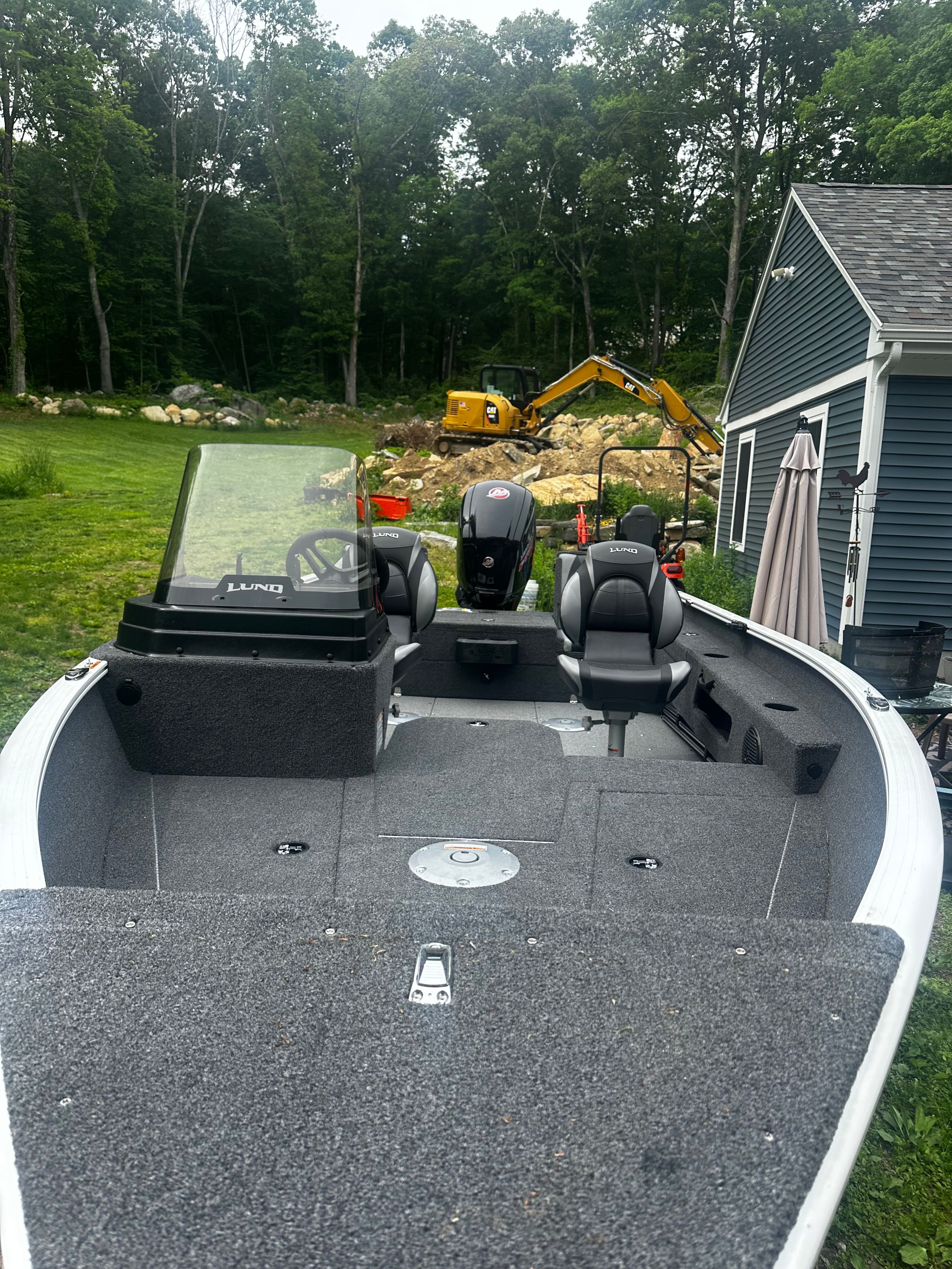 2025 Lund 1775 Adventure SS boat in yard with excavator.