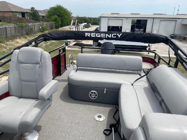 2023 Regency 250DL3 pontoon boat interior with gray seating and open deck layout.