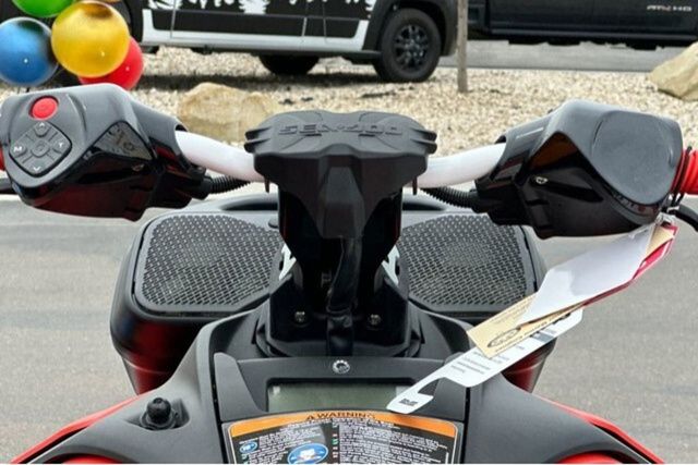 Close-up of the handlebars of a Sea-Doo PWC SPARK TRIXX 90. Colorful balloons in the background.
