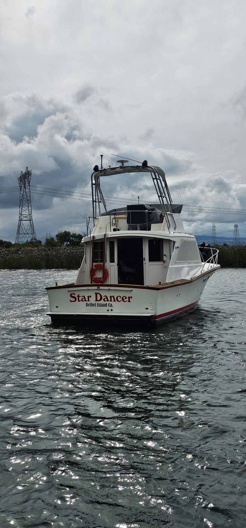 Egg Harbor 33 Sportfisher 1976 on water, cloudy sky.