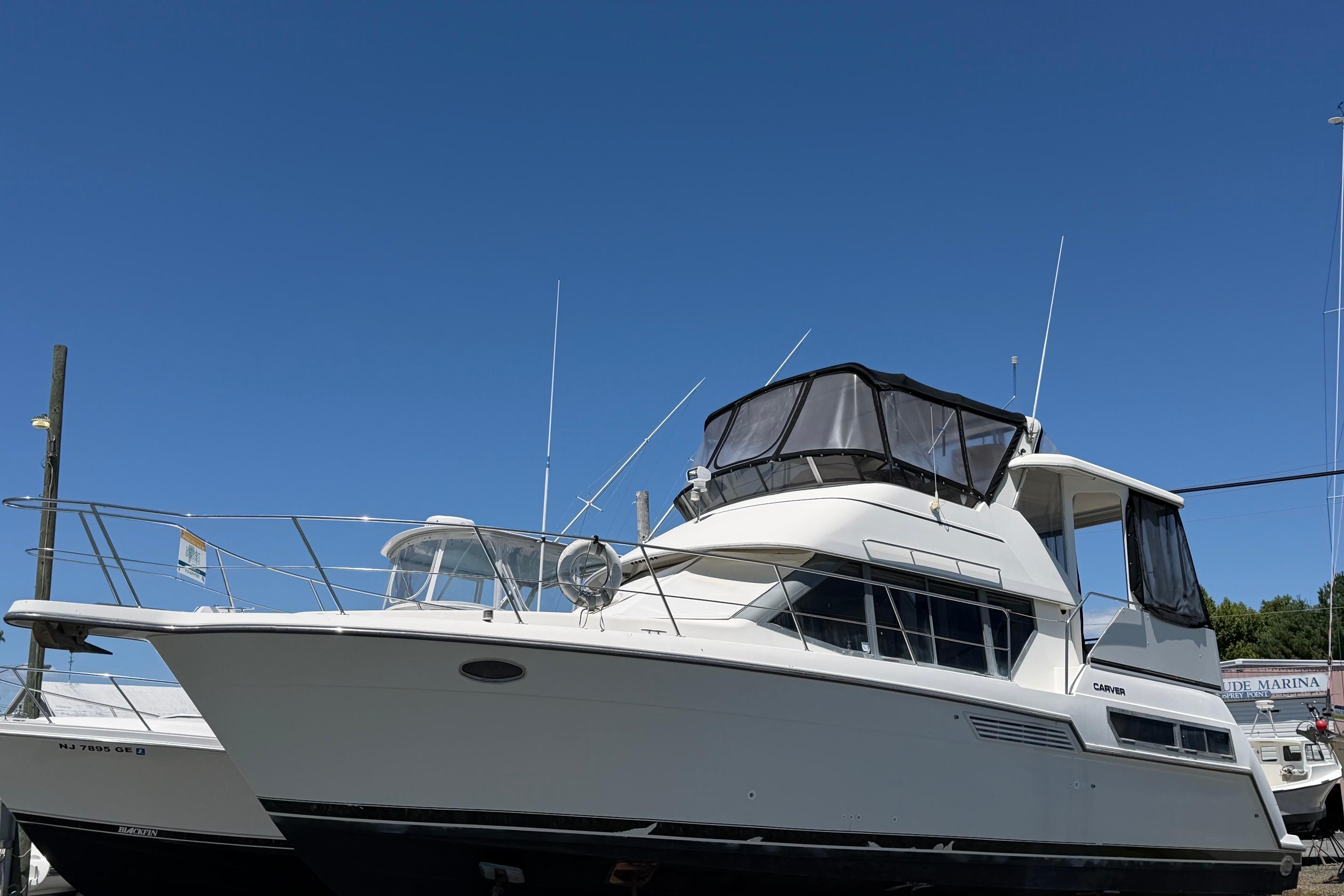 1995 Carver 356 Aft Cabin Motor Yacht docked under clear blue sky.