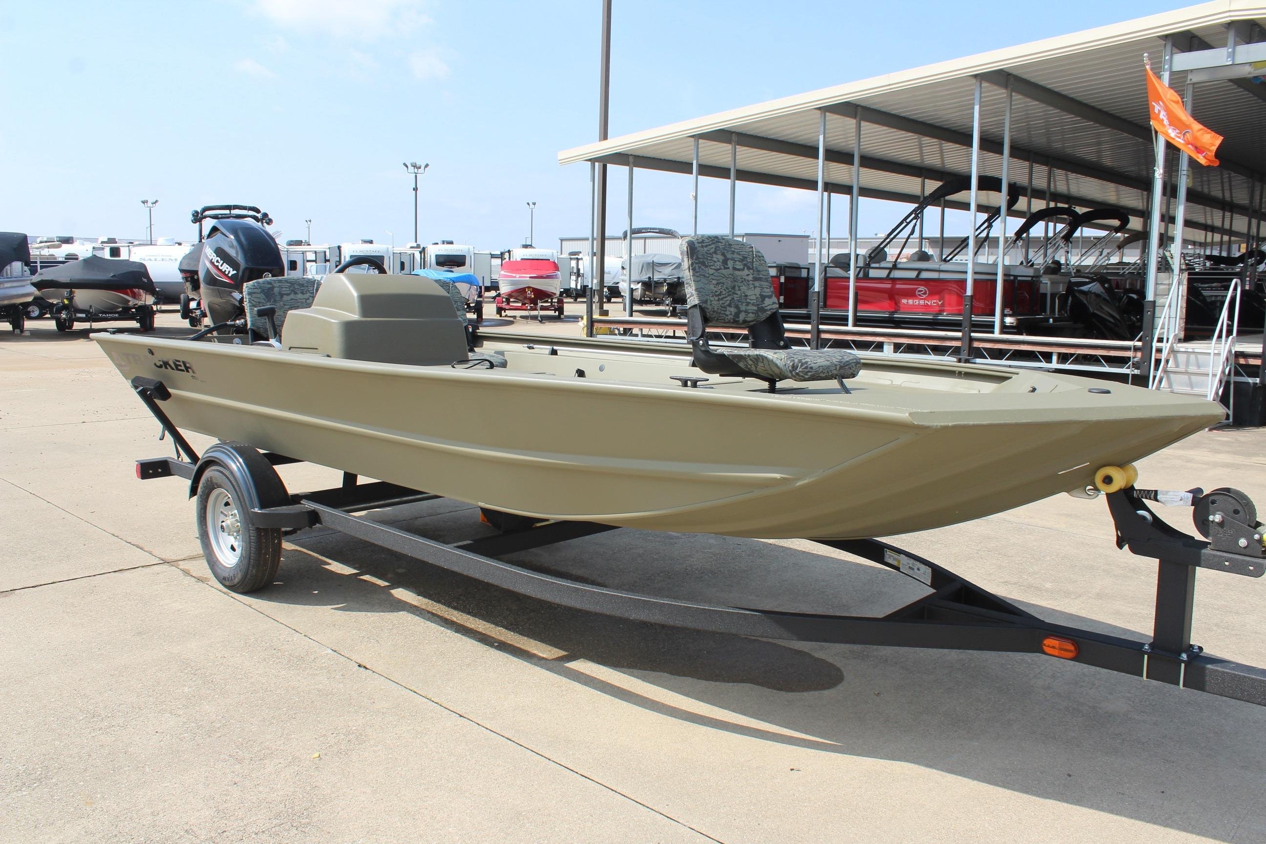 2026 Tracker Grizzly 1754 SC boat on trailer at marina, side view.