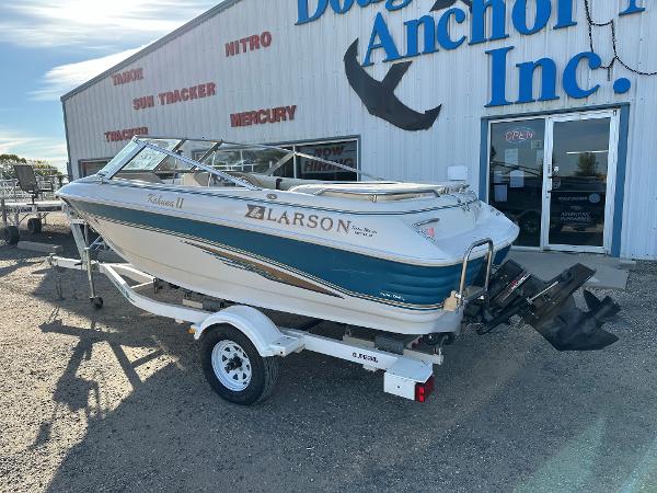 1995 Larson 174 SEI boat on trailer outside dealership, sunny day.